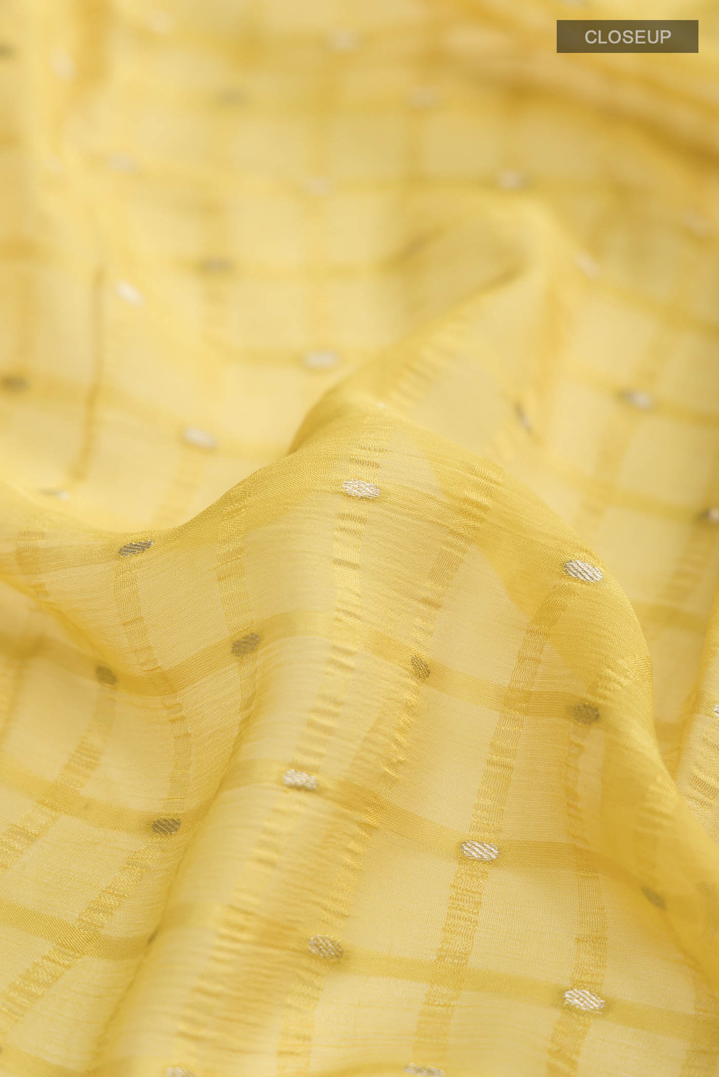 Close up of Yellow Mysore Chiffon Saree with Embroidery on the body and Zari Border displaying folds