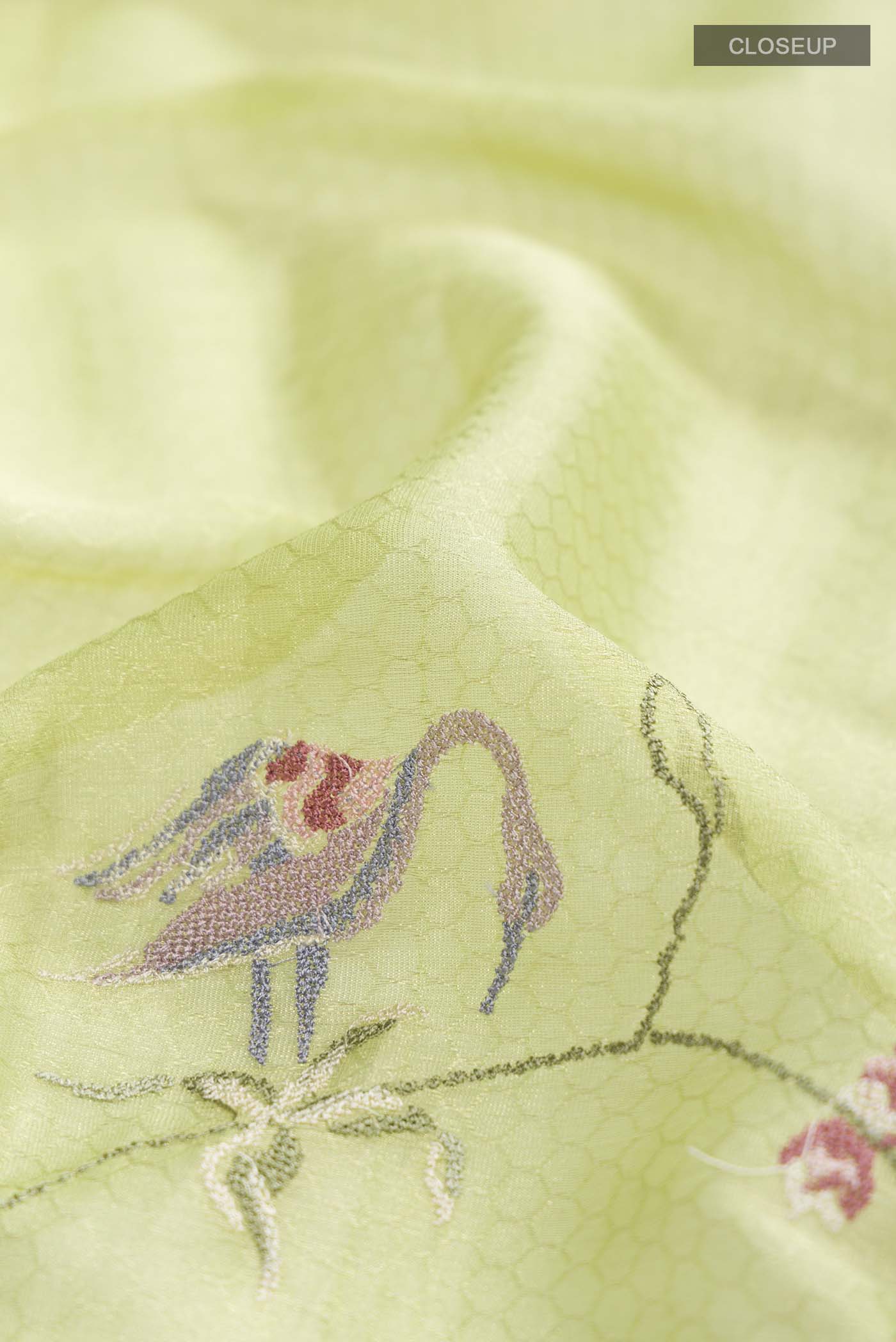 Close up of Green Mysore Georgette Saree with Embroidery on the body and Zari Border displaying folds