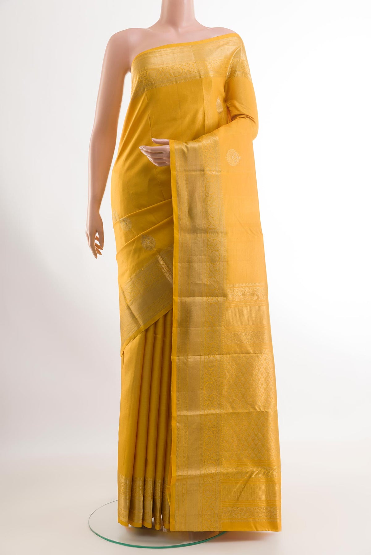 Yellow Kanchipuram Silk Saree with Zari Butta on the body and Zari Border.  displayed on a mannequin