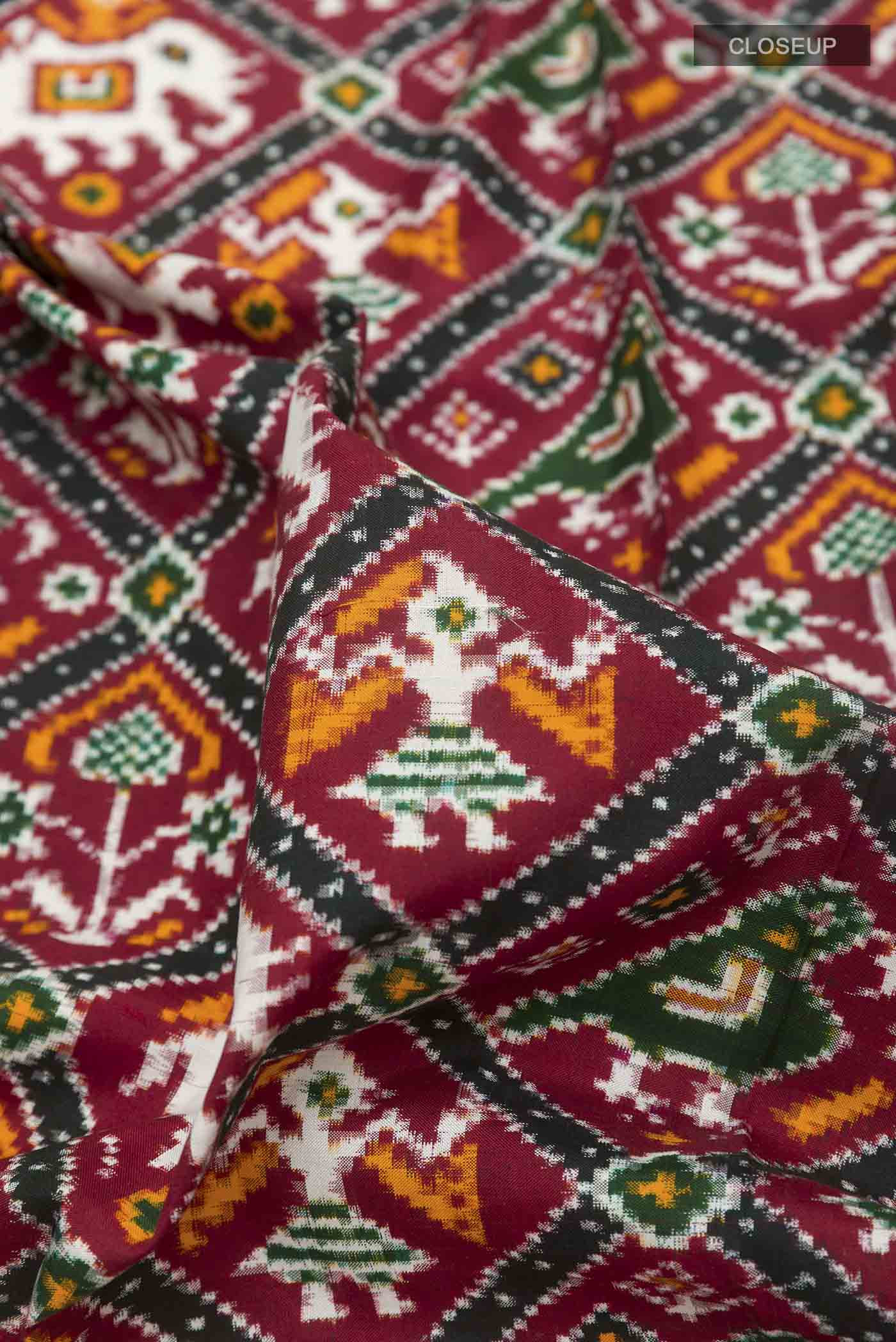 Close up of Maroon Pochampally Silk Saree with Pure Ikat on the body and Ikat Border displaying folds