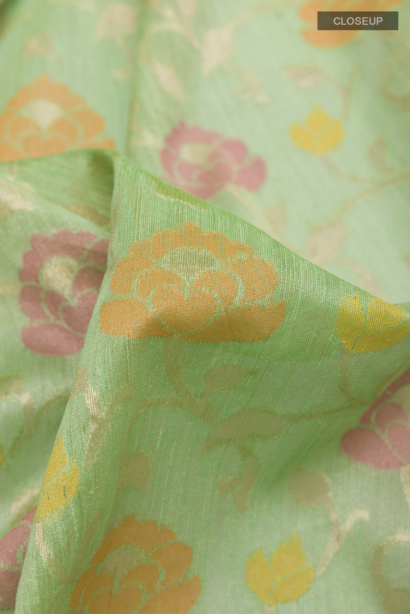 Close up of Green Banarasi Kora Silk Saree with Thread Brocade on the body and Zari Border displaying folds