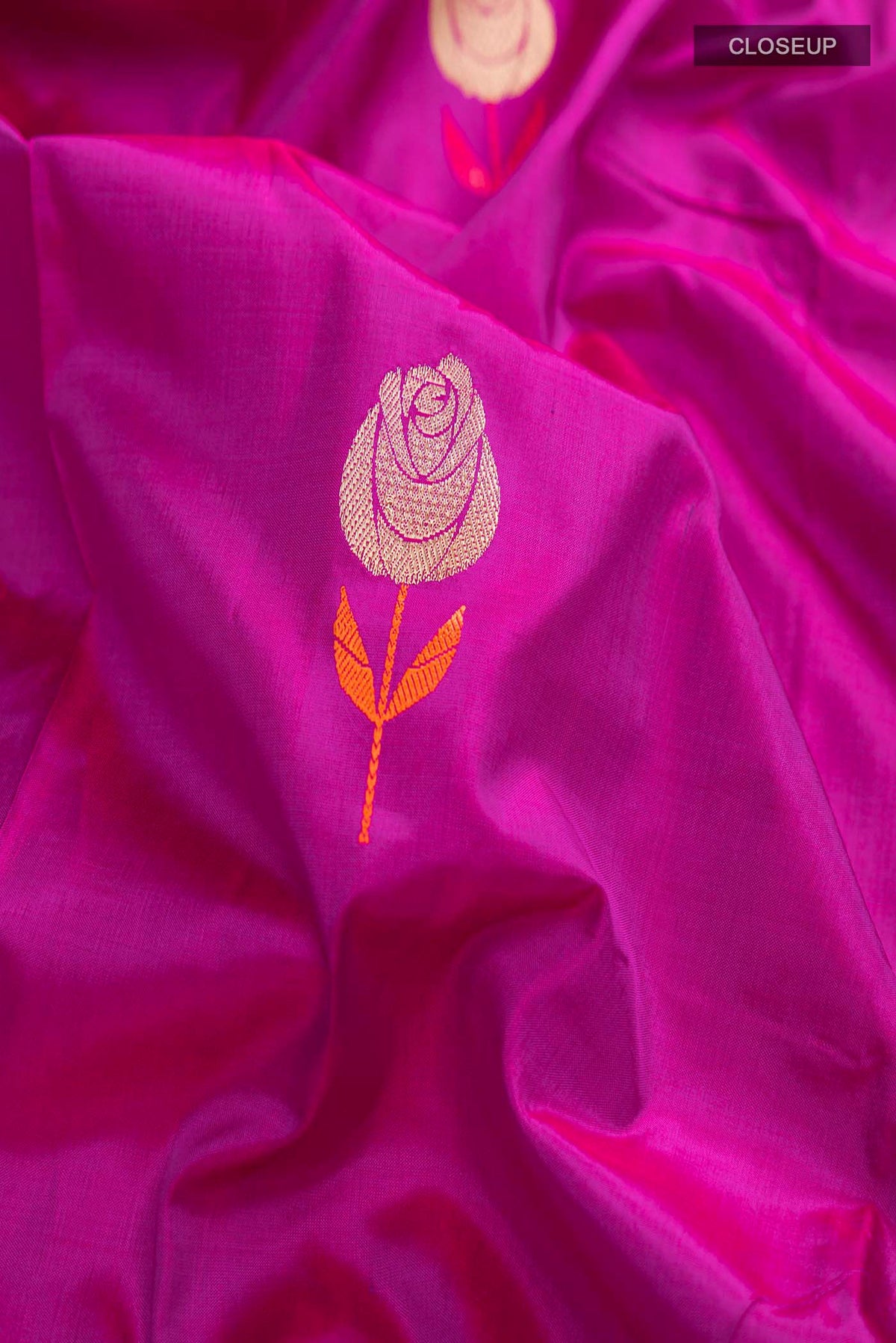Close up of Magenta Banarasi Katan Silk Saree with Zari Butta on the body and Zari Border displaying folds