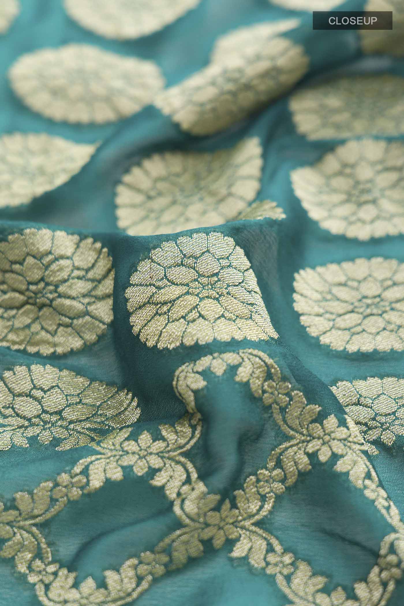 Close up of Green Banarasi Georgette Saree with Zari Butta on the body and Zari Border displaying folds