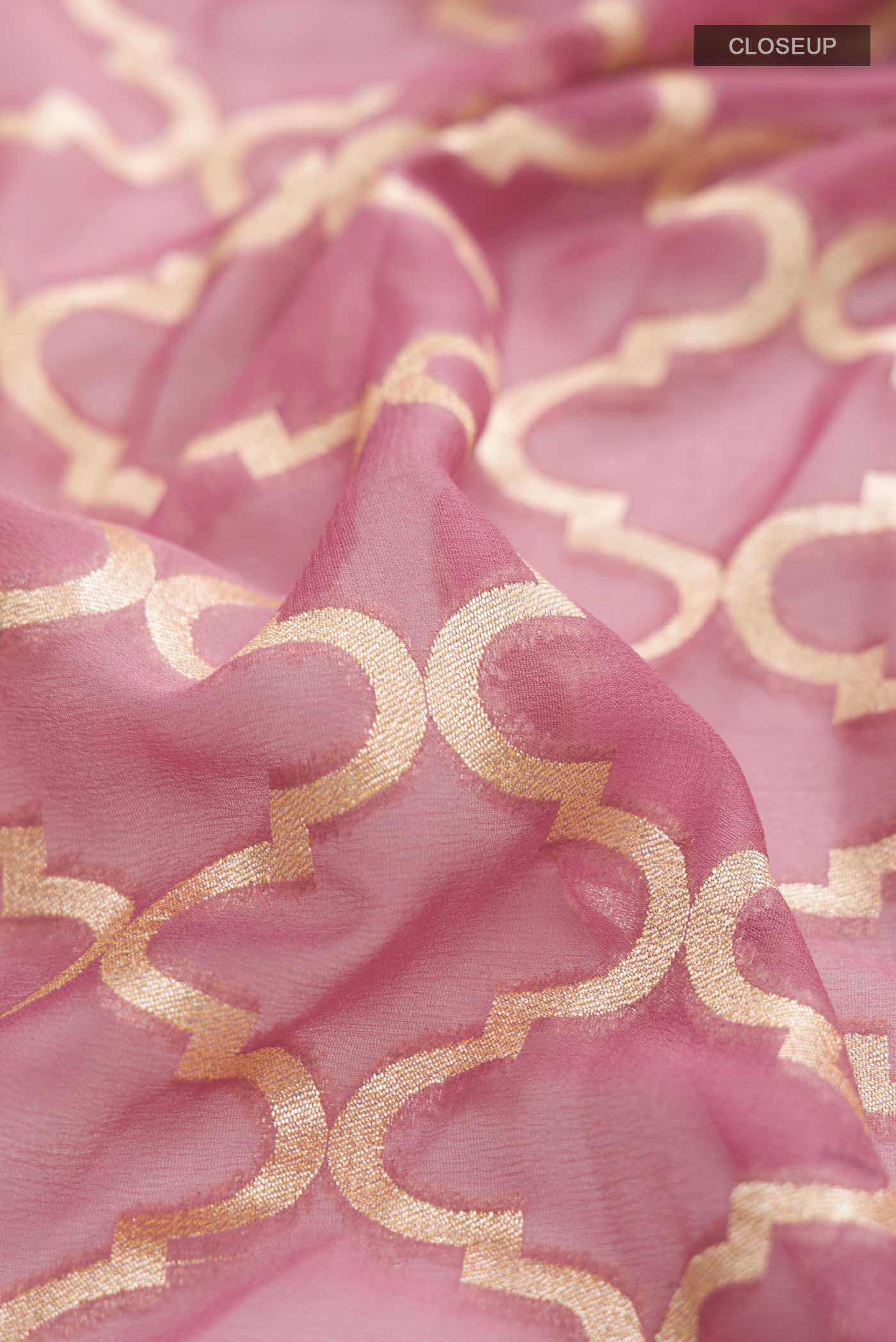 Close up of Pink Banarasi Georgette Saree with Zari Butta on the body and Zari Border displaying folds