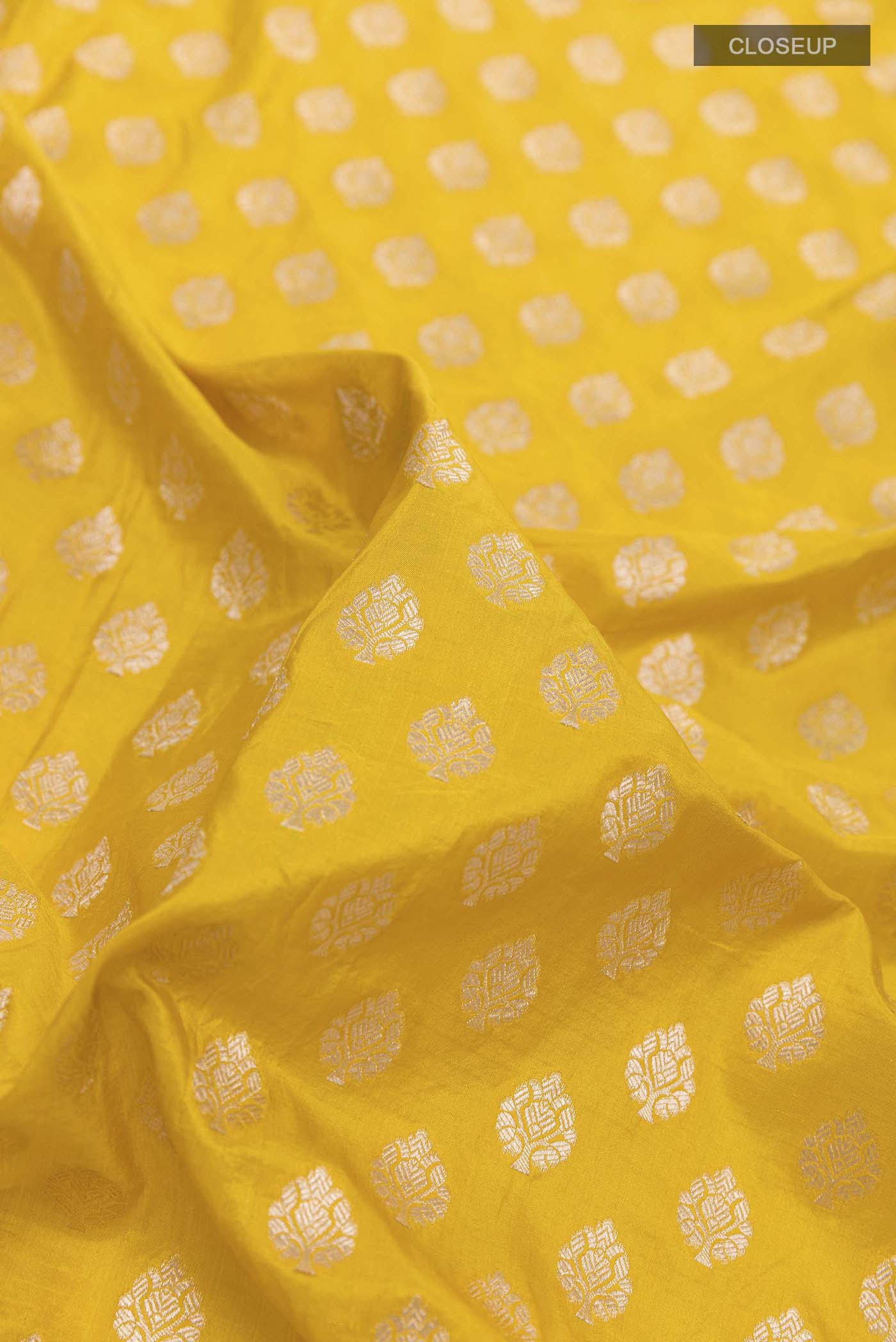 Close up of Yellow Banarasi Silk Saree with Zari Butta on the body and Sequin Border displaying folds