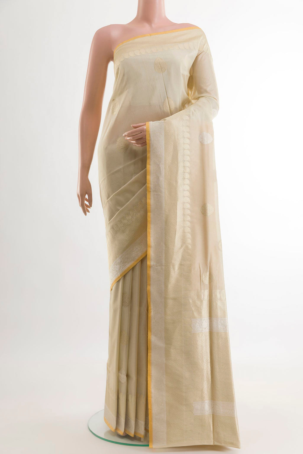 Cream Banarasi Silk Saree with Zari Butta on the body and Zari Border.  displayed on a mannequin