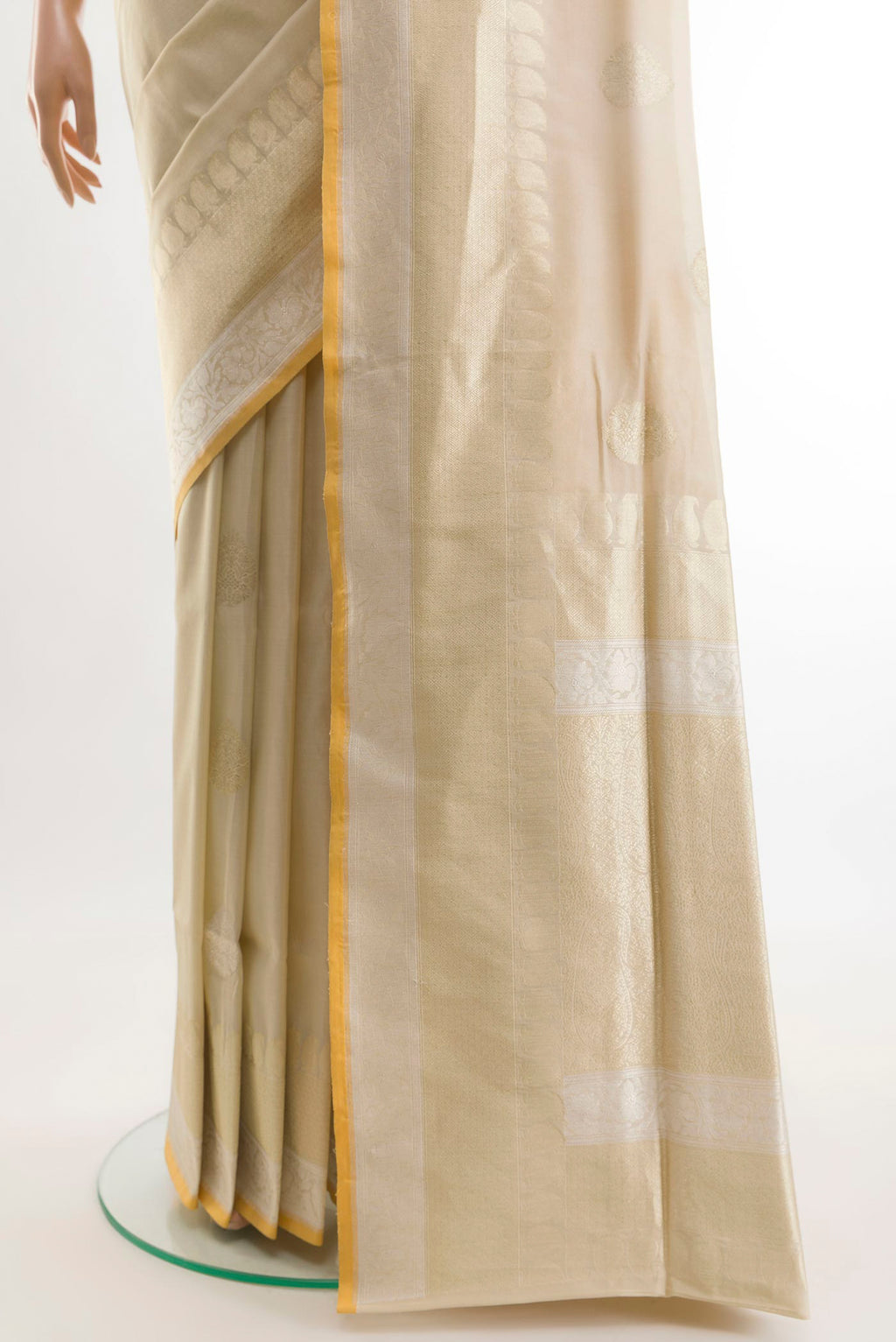 Pleats and pallu of Cream Banarasi Silk Saree with Zari Butta on the body and Zari Border. 