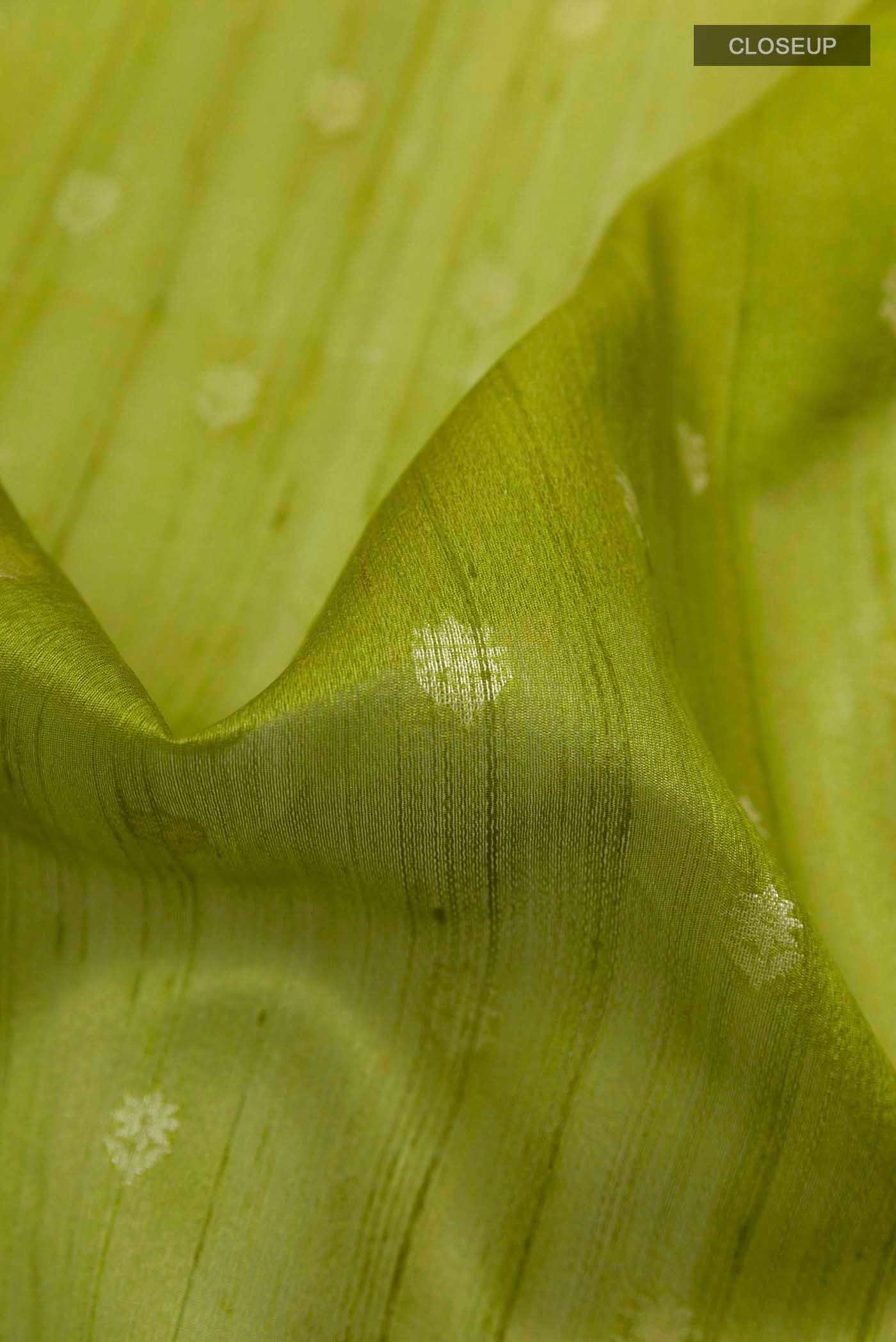 Close up of Pickle Green Banarasi Tussar Silk Saree with Zari Butta on the body and Zari Border displaying folds