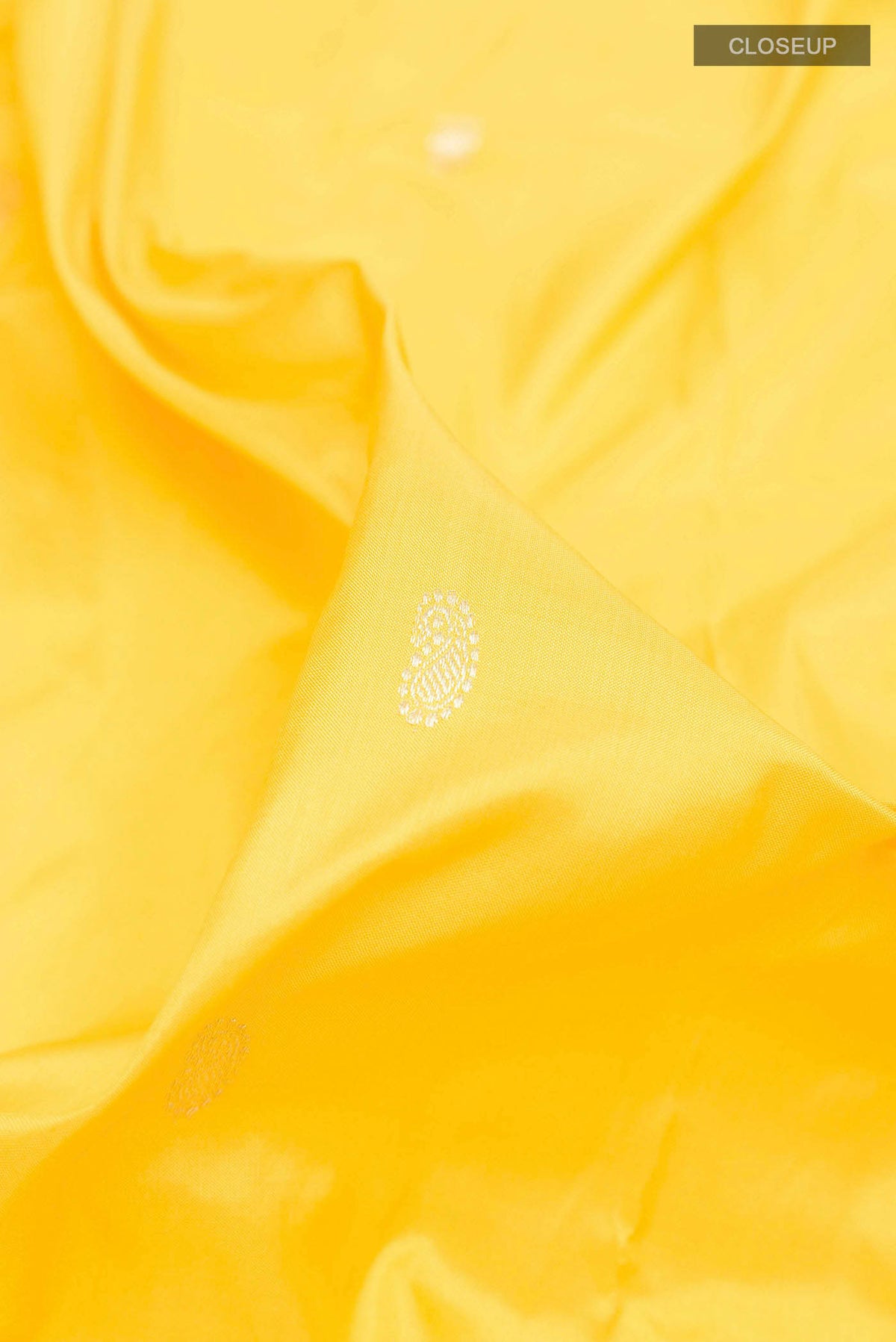 Close up of Yellow Dual Tone Paithani Silk Saree with Zari Butta on the body and Zari Border displaying folds