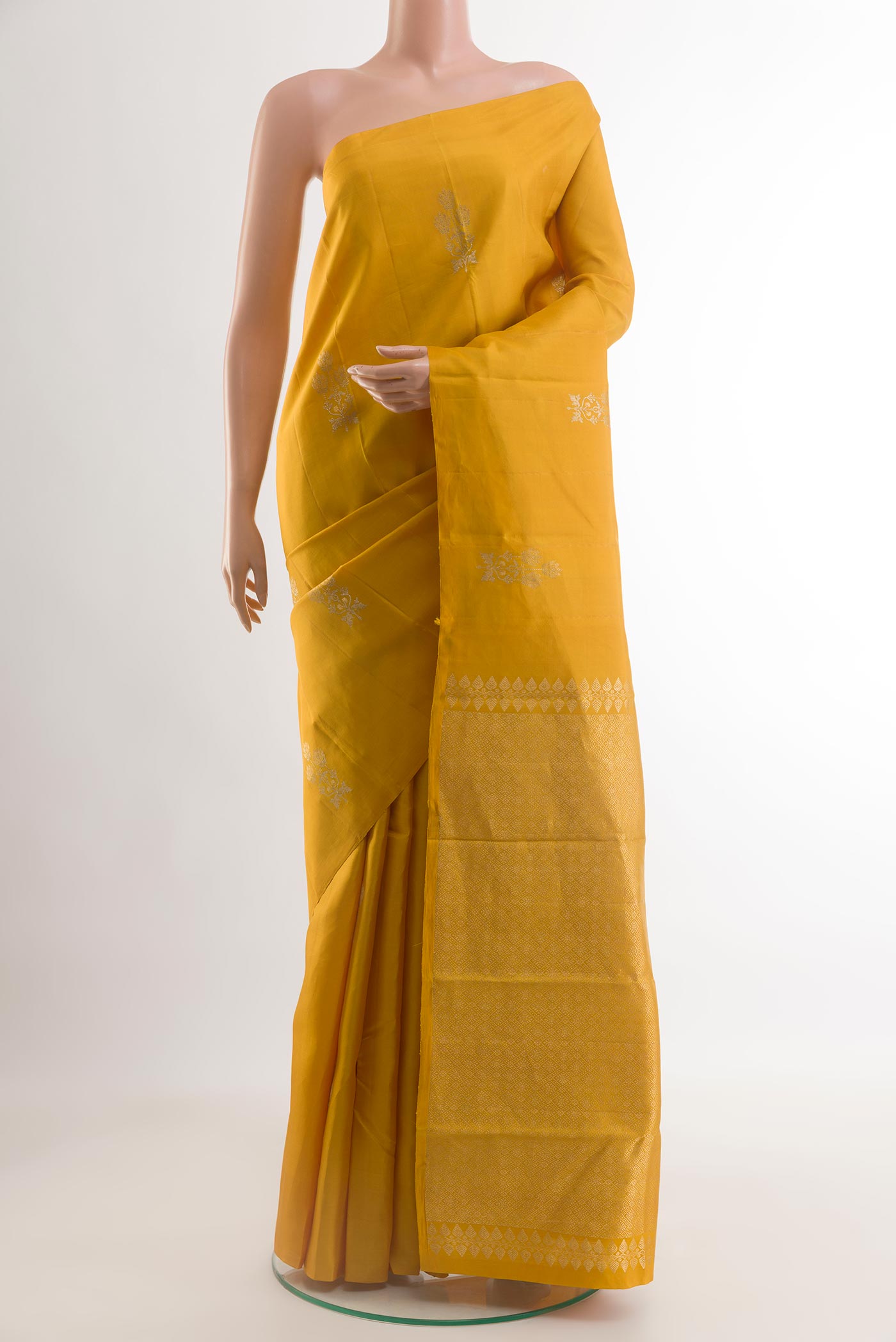 Mustard Kanjivaram Silk Saree with Zari Butta on the body and Without Border.  displayed on a mannequin