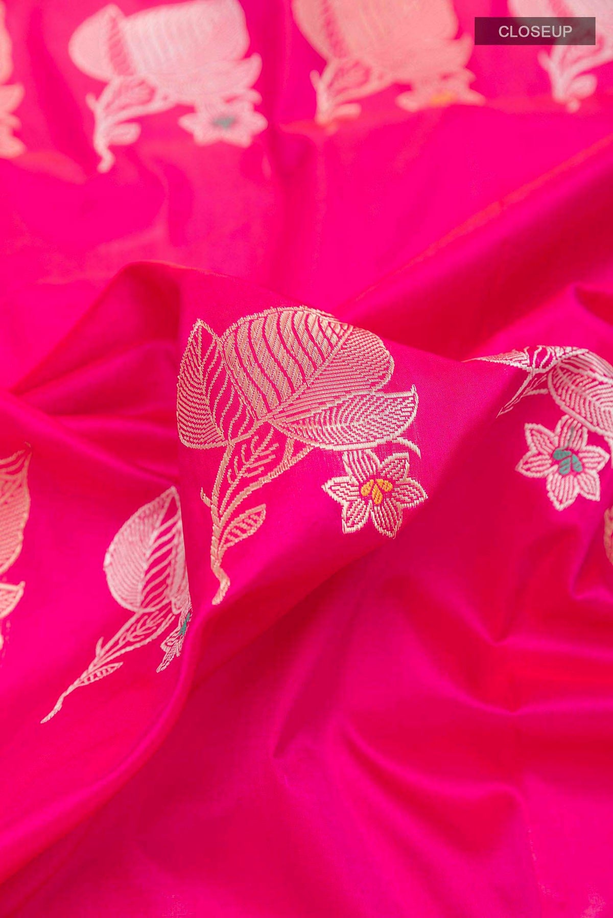 Close up of Pink Banarasi Saree with Zari Butta on the body and Zari Border displaying folds