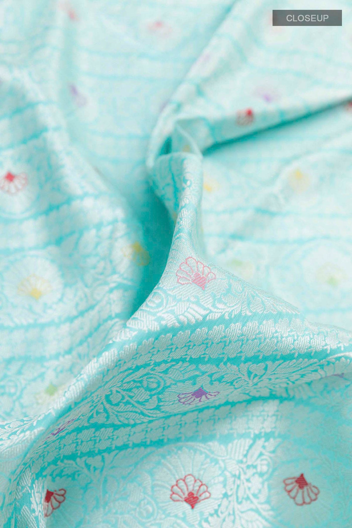 Close up of Turquoise Banarasi Saree with Zari Brocade on the body and Zari Border displaying folds