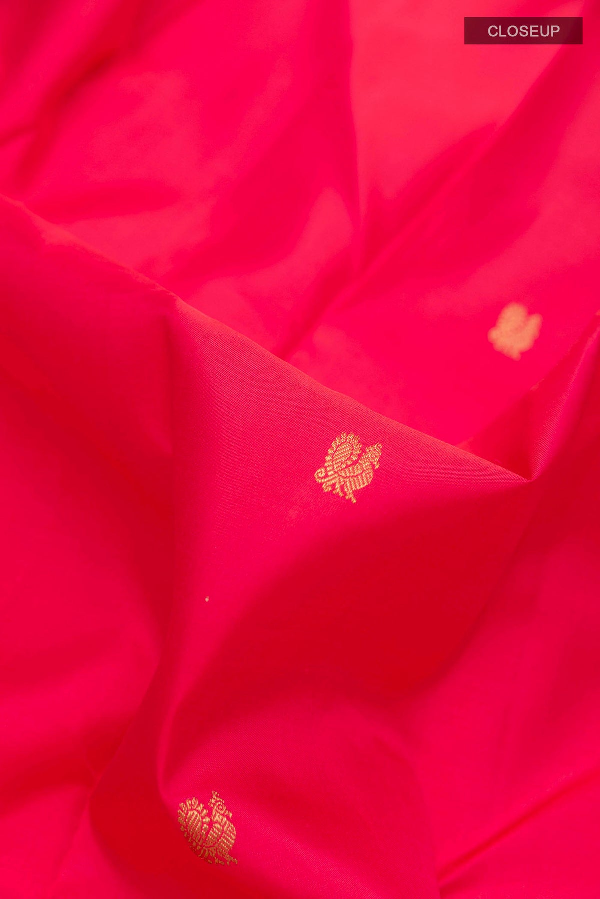 Close up of Pink Kanchipuram Silk Saree with Zari Butta on the body and Zari Border displaying folds