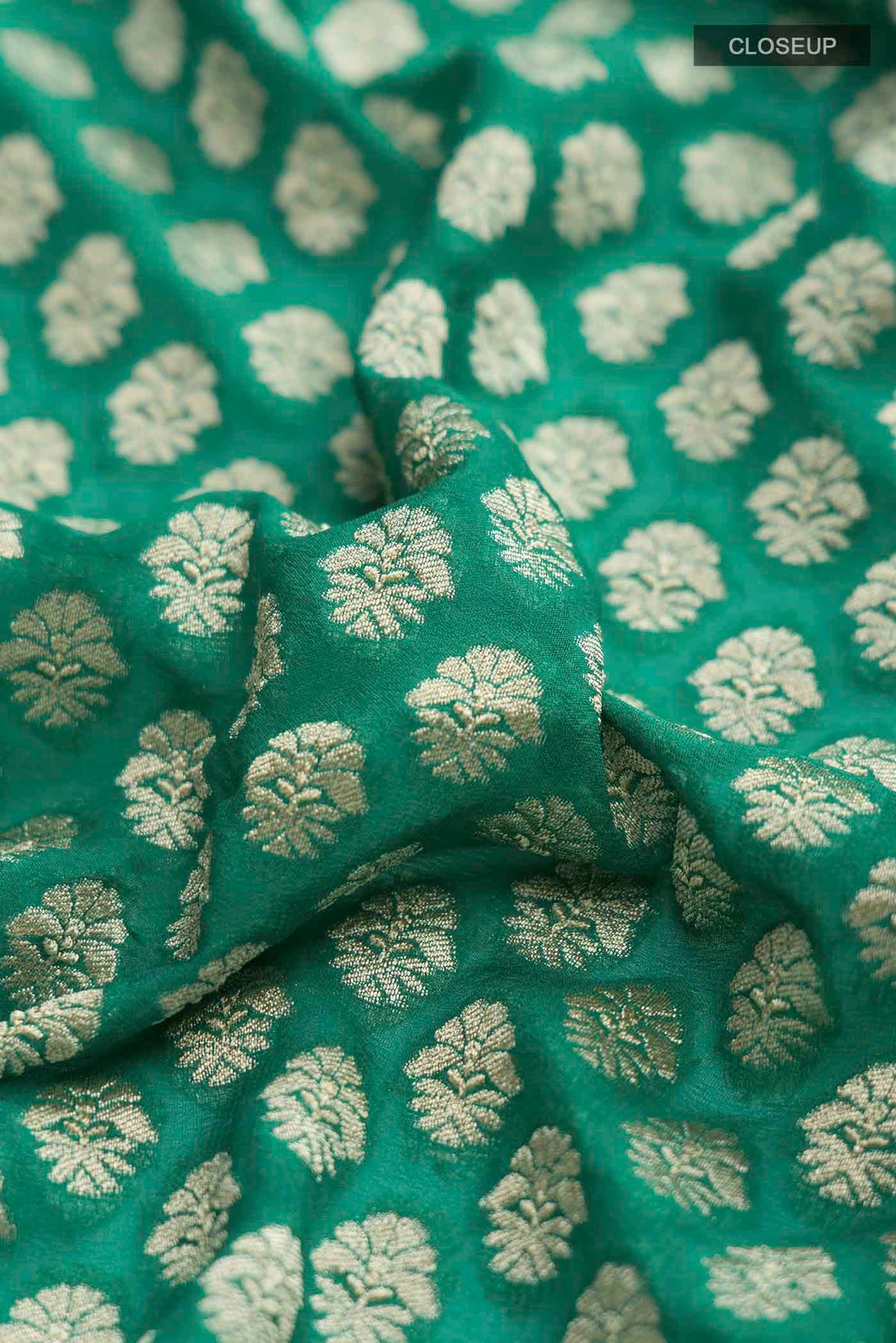 Close up of Green Banarasi Georgette Saree with Zari Butta on the body and Zari Border displaying folds