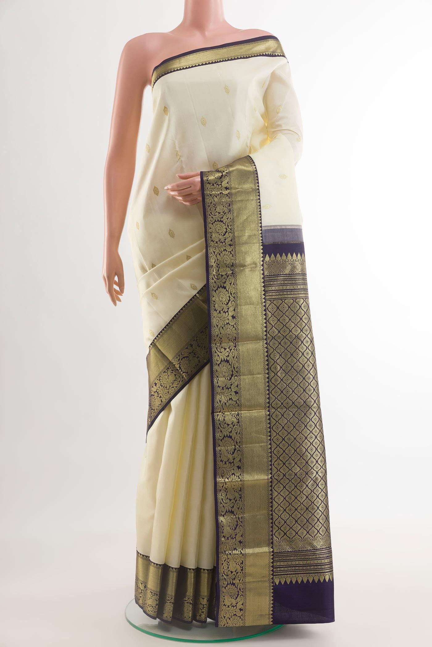 Off White Kanjivaram Silk Saree with Zari Butta on the body and Zari Border.  displayed on a mannequin
