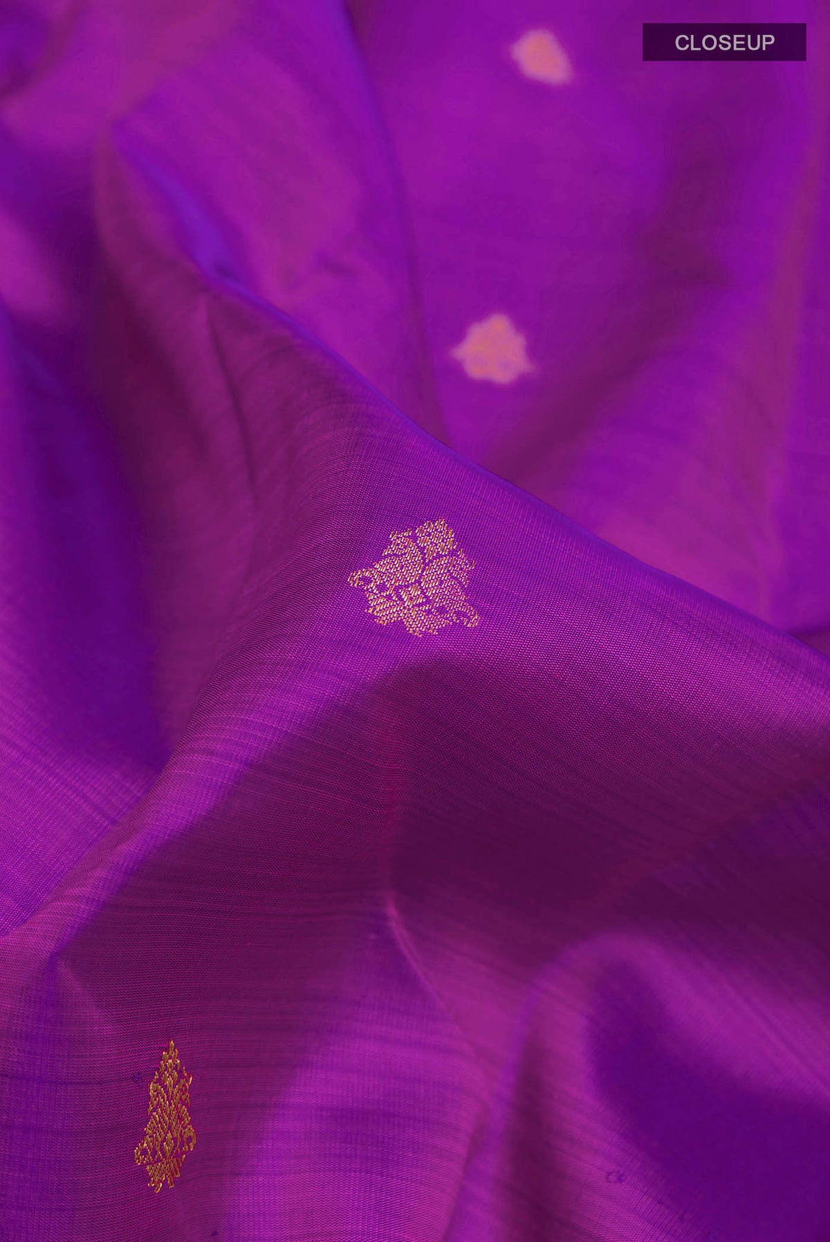 Close up of Purple Kanchipuram Silk Saree with Zari Butta on the body and Zari Border displaying folds