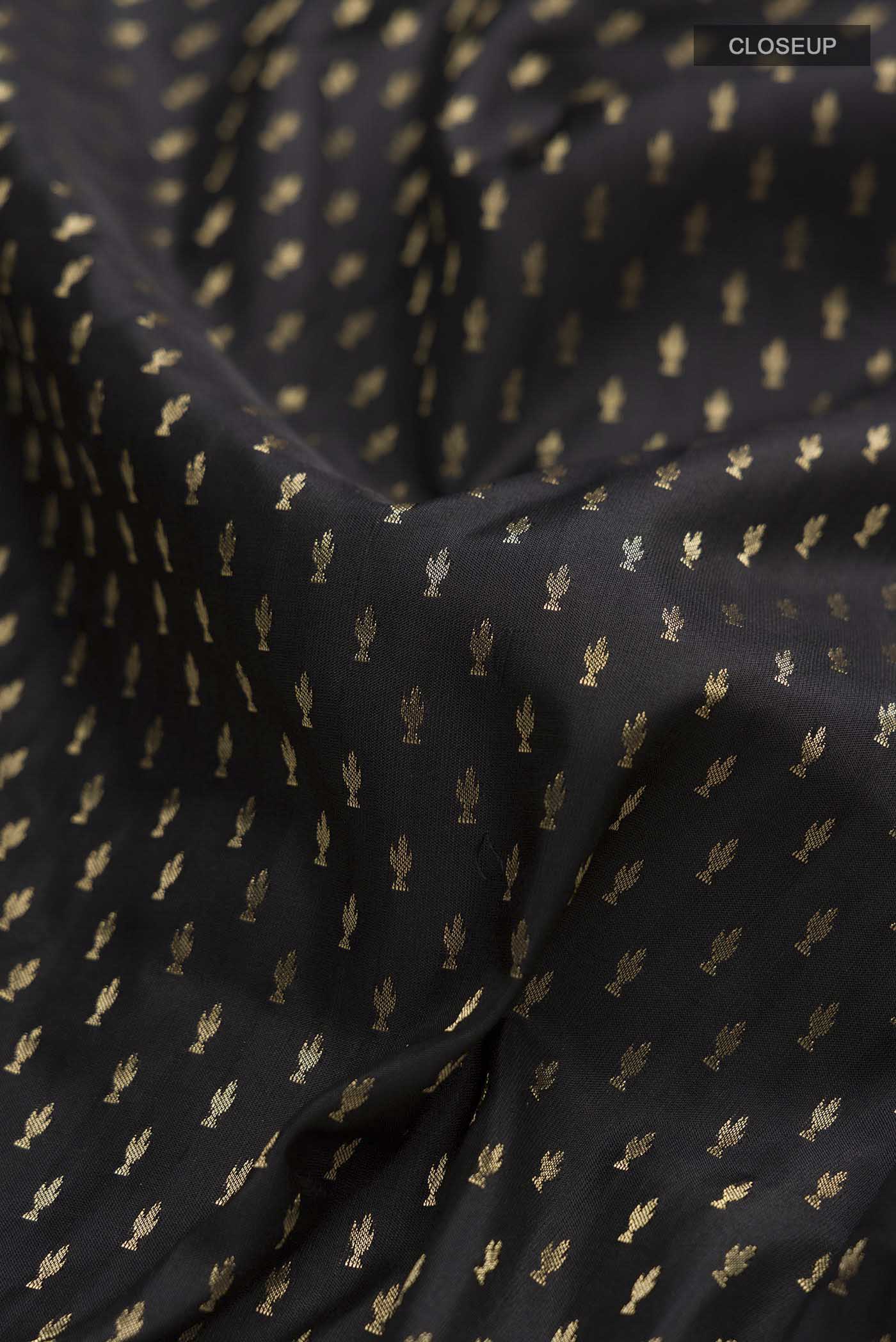 Close up of Black Soft Silk Saree with Zari Butta on the body and Zari Border displaying folds