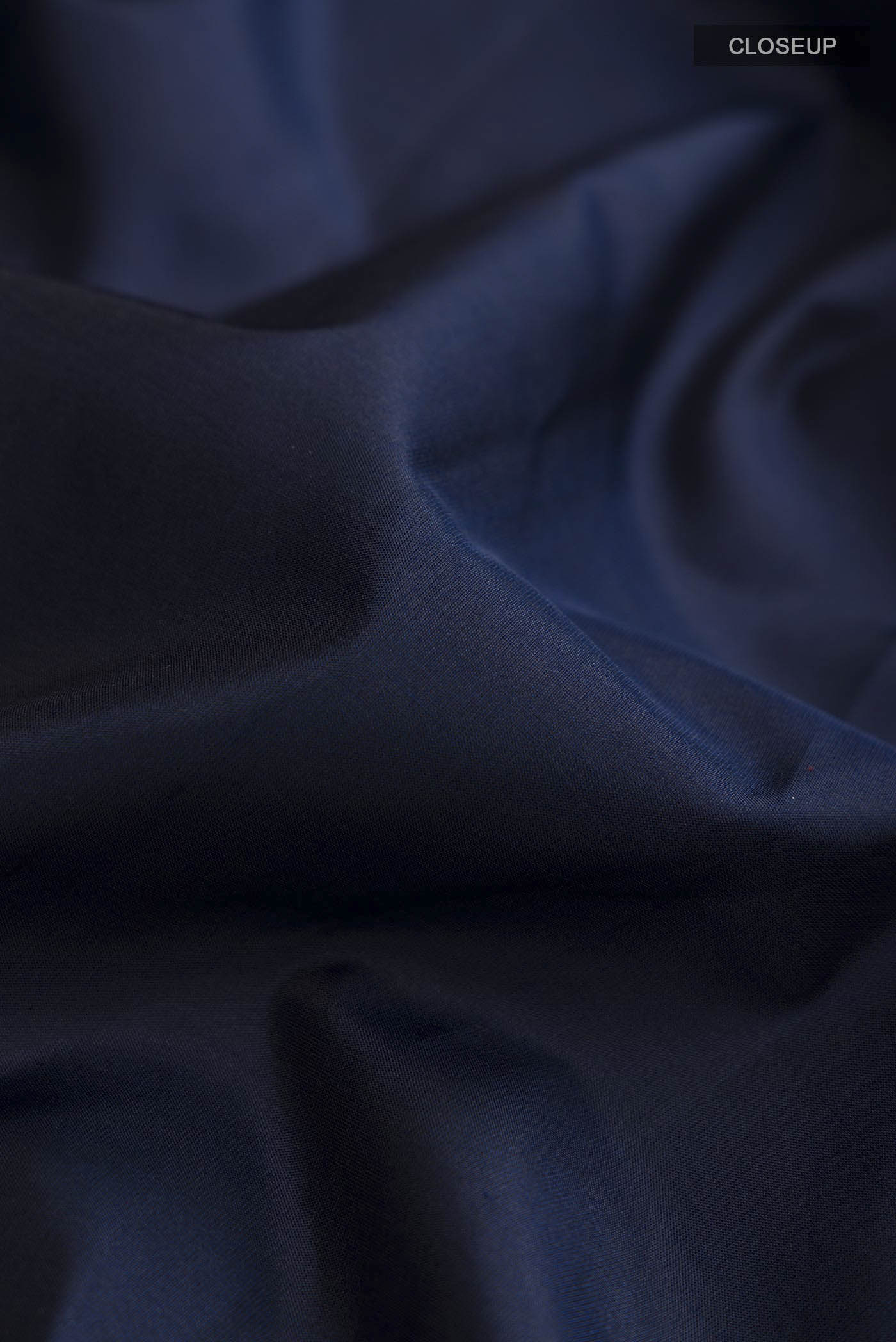 Close up of Navy Blue Soft Silk Saree with Plain Body and Zari Border displaying folds