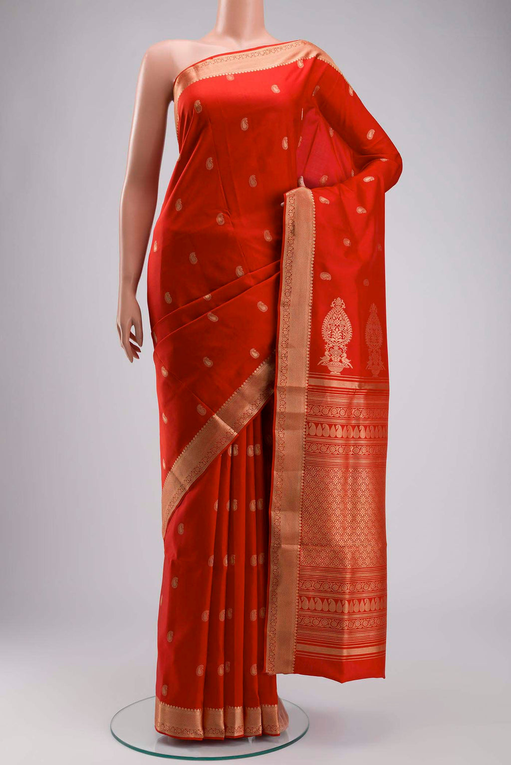 Orange Soft Silk Saree with Zari Butta on the body and Zari Border displayed on a mannequin