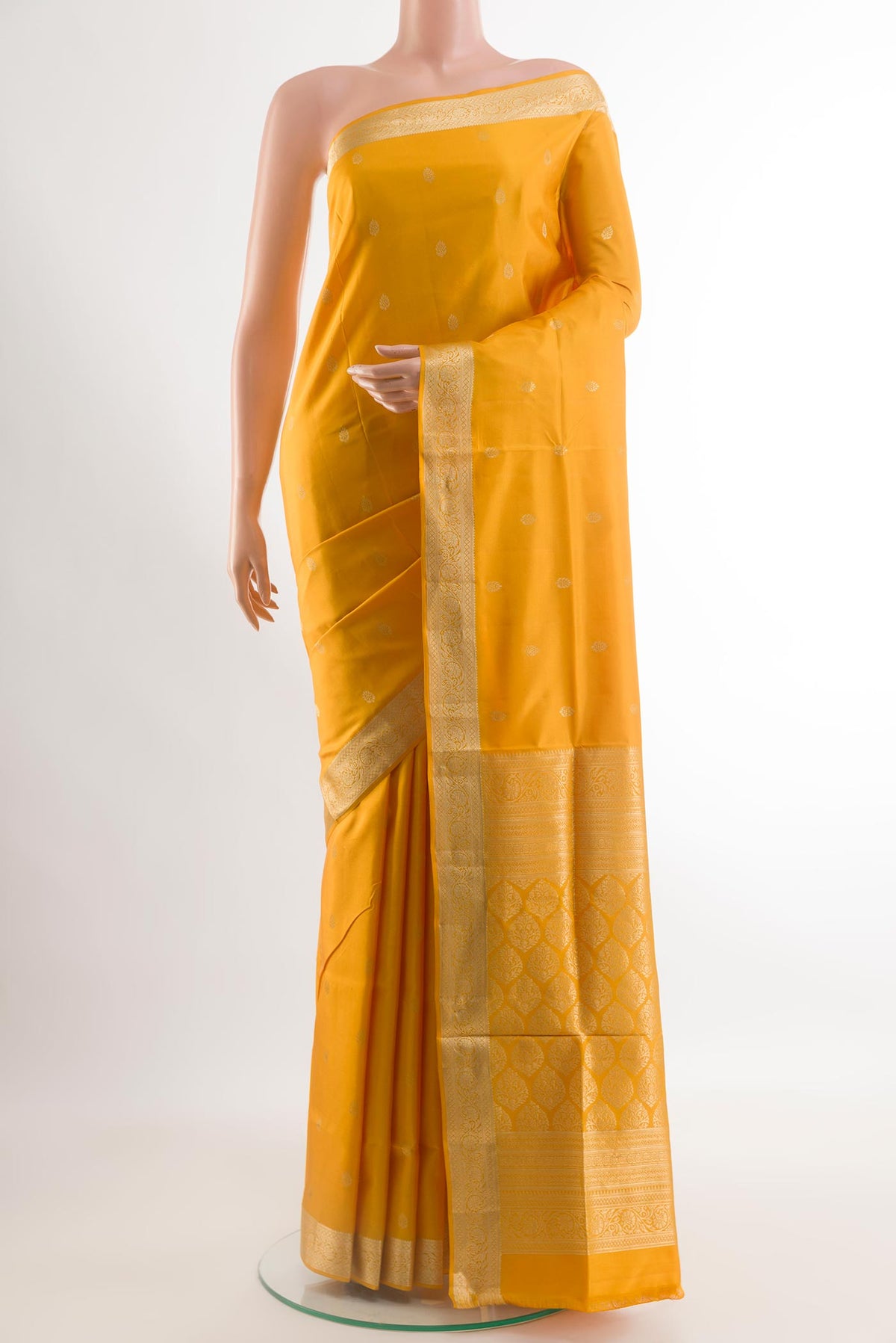 Mustard Soft Silk Saree with Zari Butta on the body and Zari Border.  displayed on a mannequin