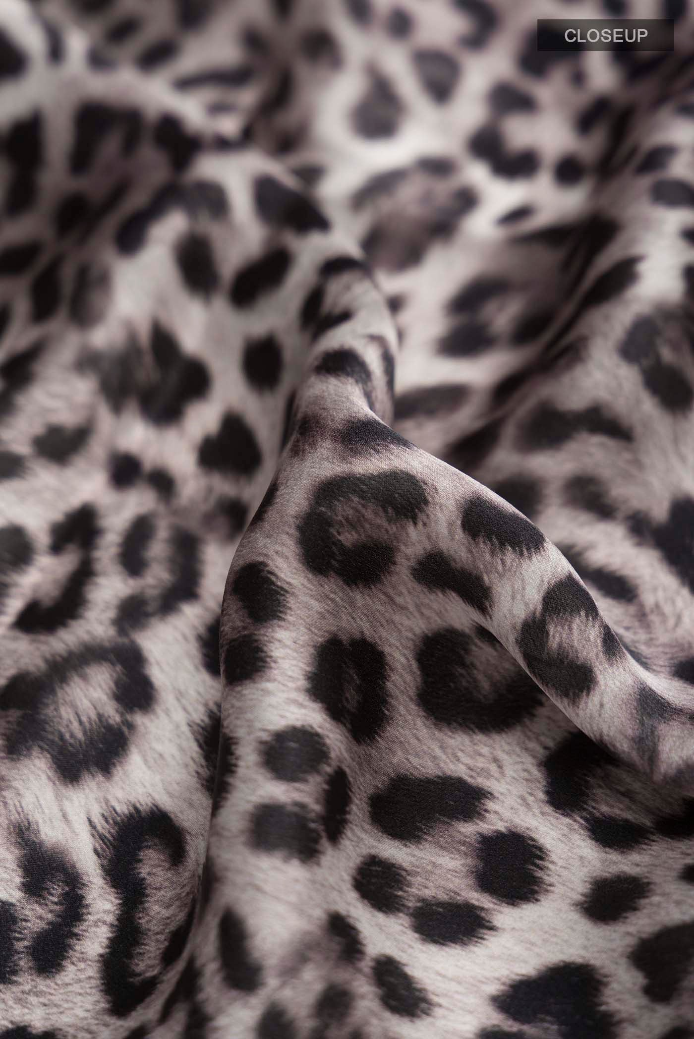 Close up of Grey Crepe Saree with Printed design on the body and Plain Border displaying folds