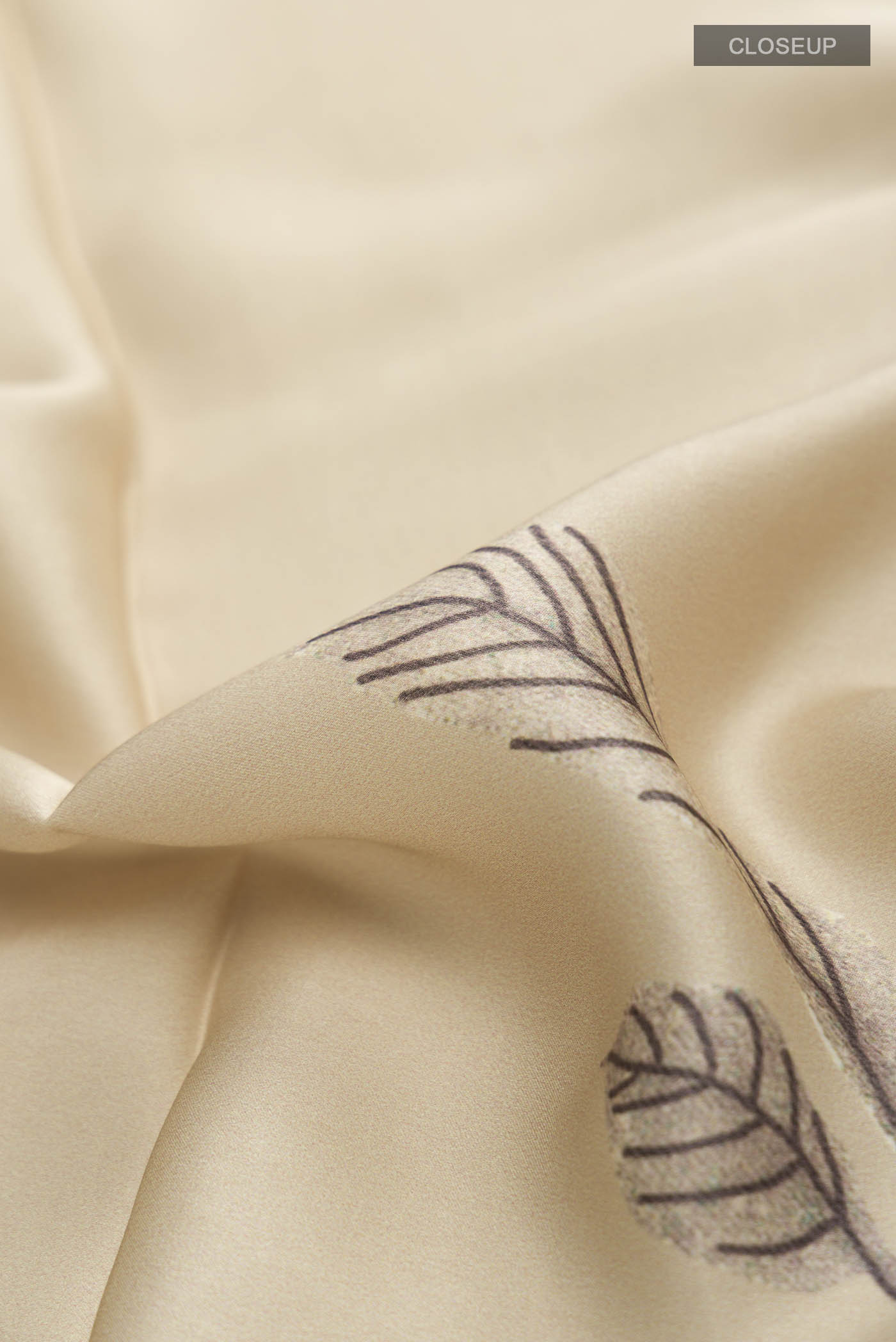 Close up of Beige Satin Silk Saree with Plain Body and Printed Border displaying folds