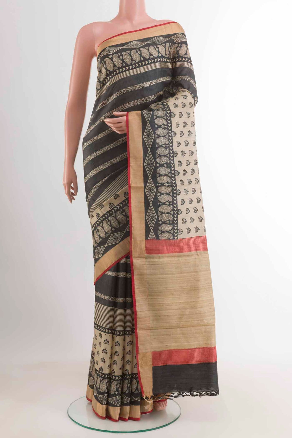 Black Tussar Saree with Printed design on the body and Zari Border displayed on a mannequin