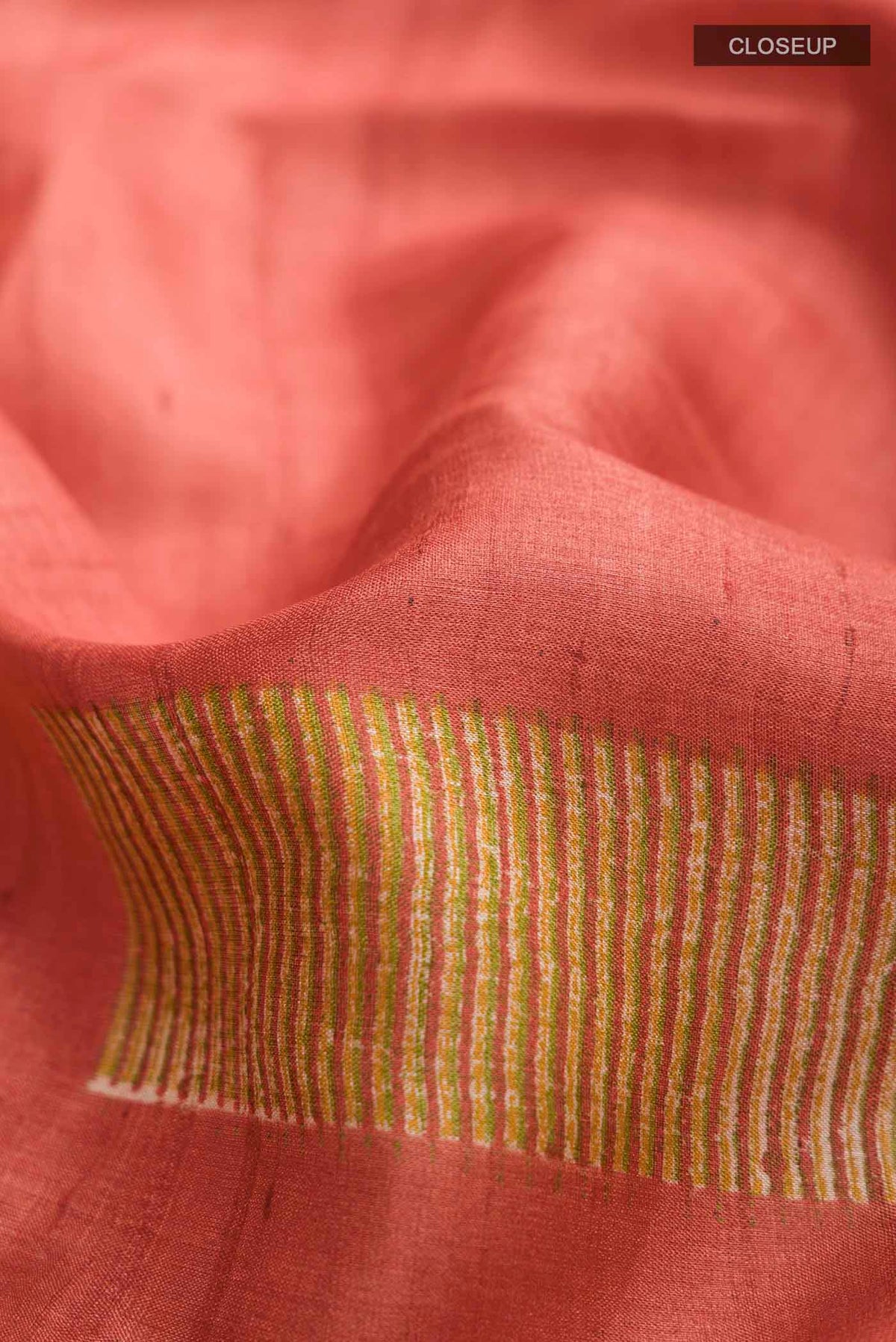 Close up of Rust Bhagalpuri Tussar Silk Saree with Printed design on the body and Plain Border displaying folds