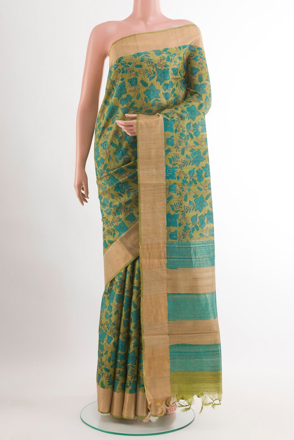 Green Tussar Saree with Printed design on the body and Zari Border.  displayed on a mannequin