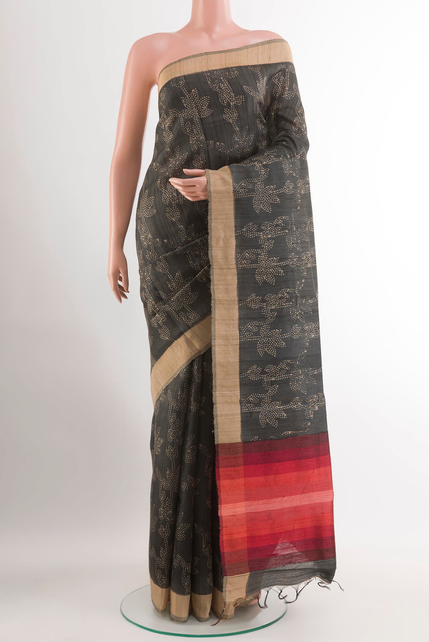 Black Tussar Saree with Printed design on the body and Zari Border.  displayed on a mannequin