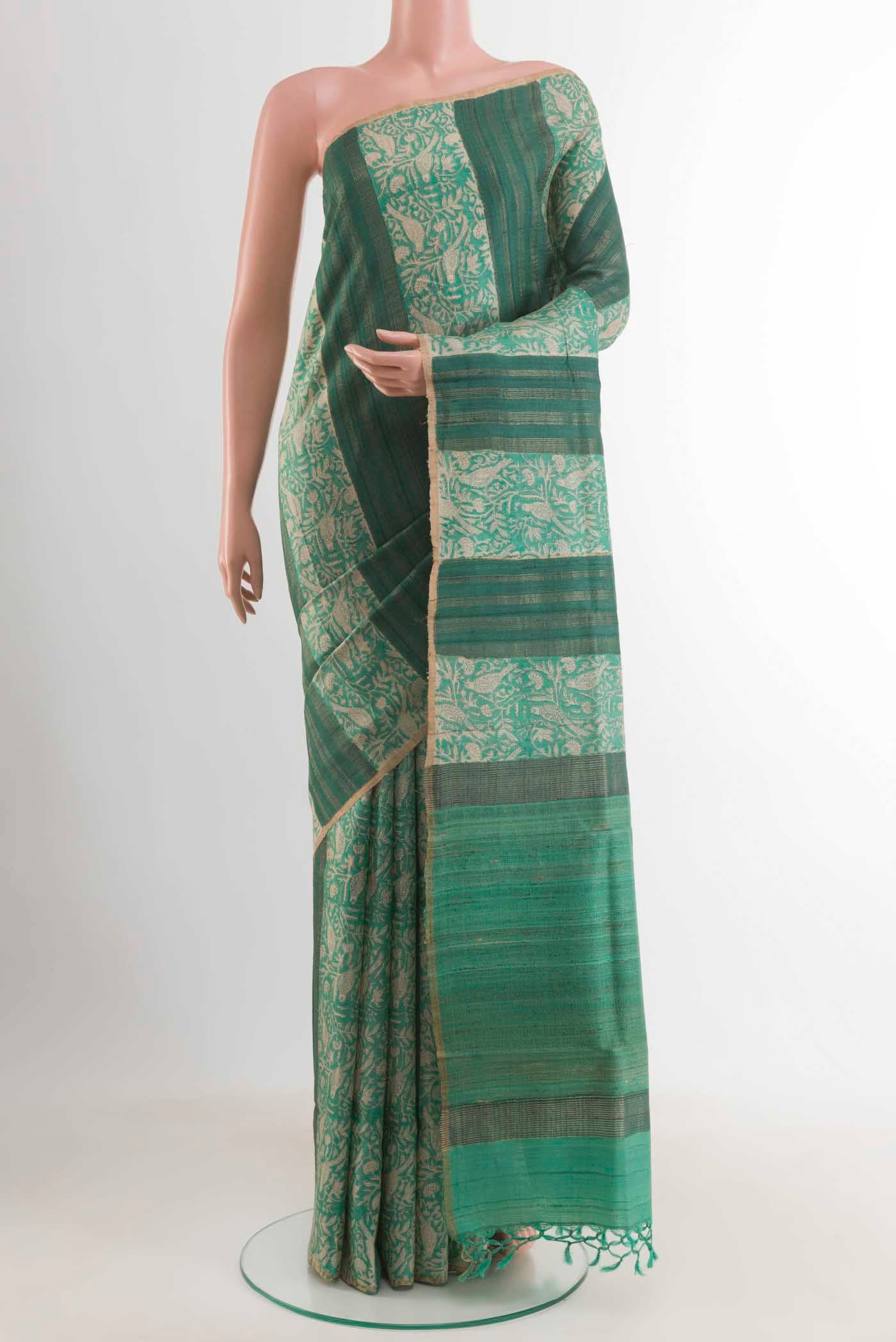 Sea Green Tussar Saree with Printed design on the body and Zari Border displayed on a mannequin