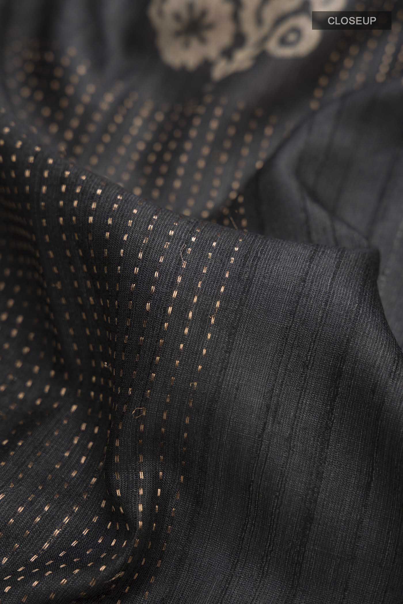 Close up of Black Bhagalpuri Tussar Silk Saree with Printed design on the body and Plain Border displaying folds