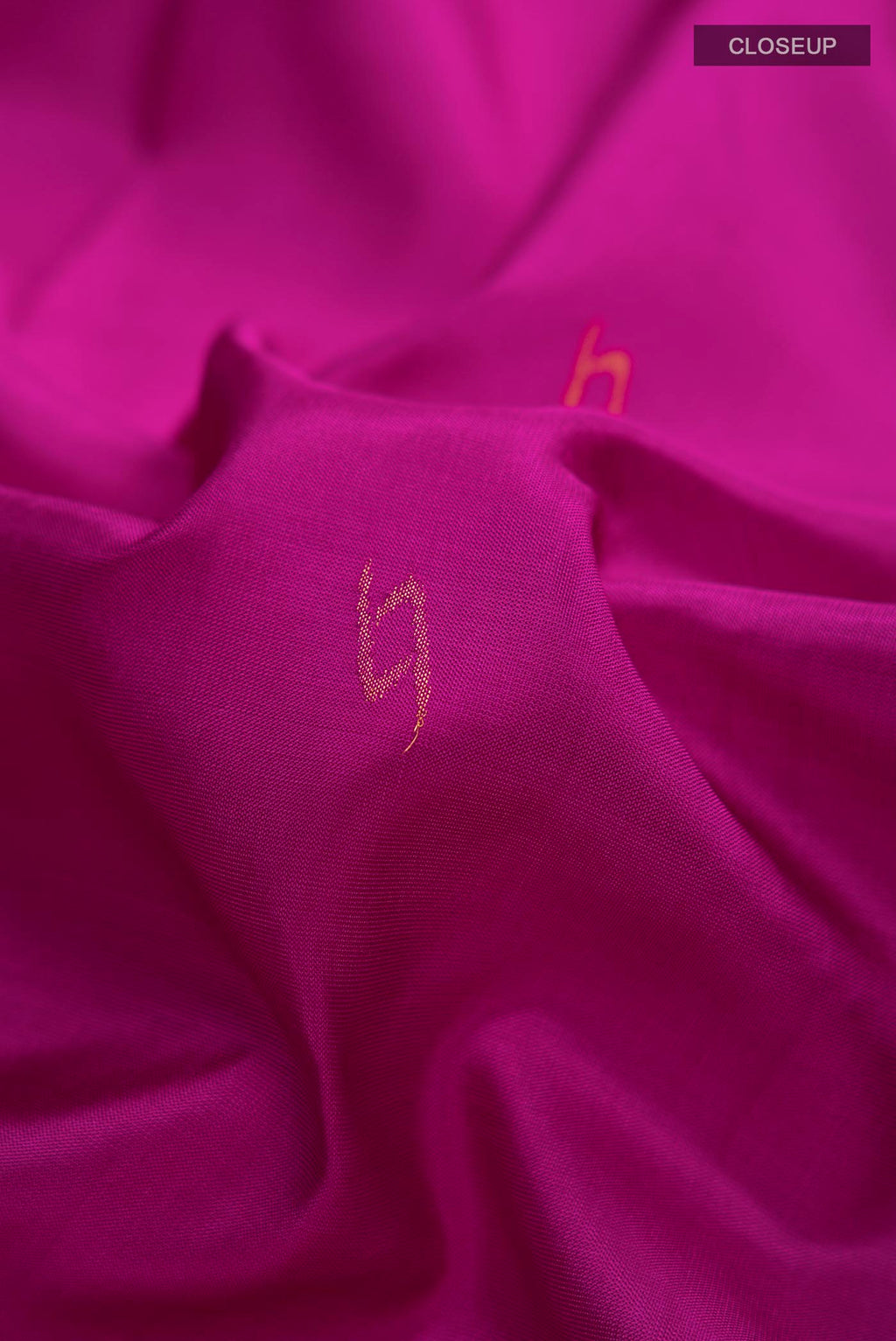 Close up of Magenta Uppada Silk Saree with Thread Butta on the body and Zari Border displaying folds