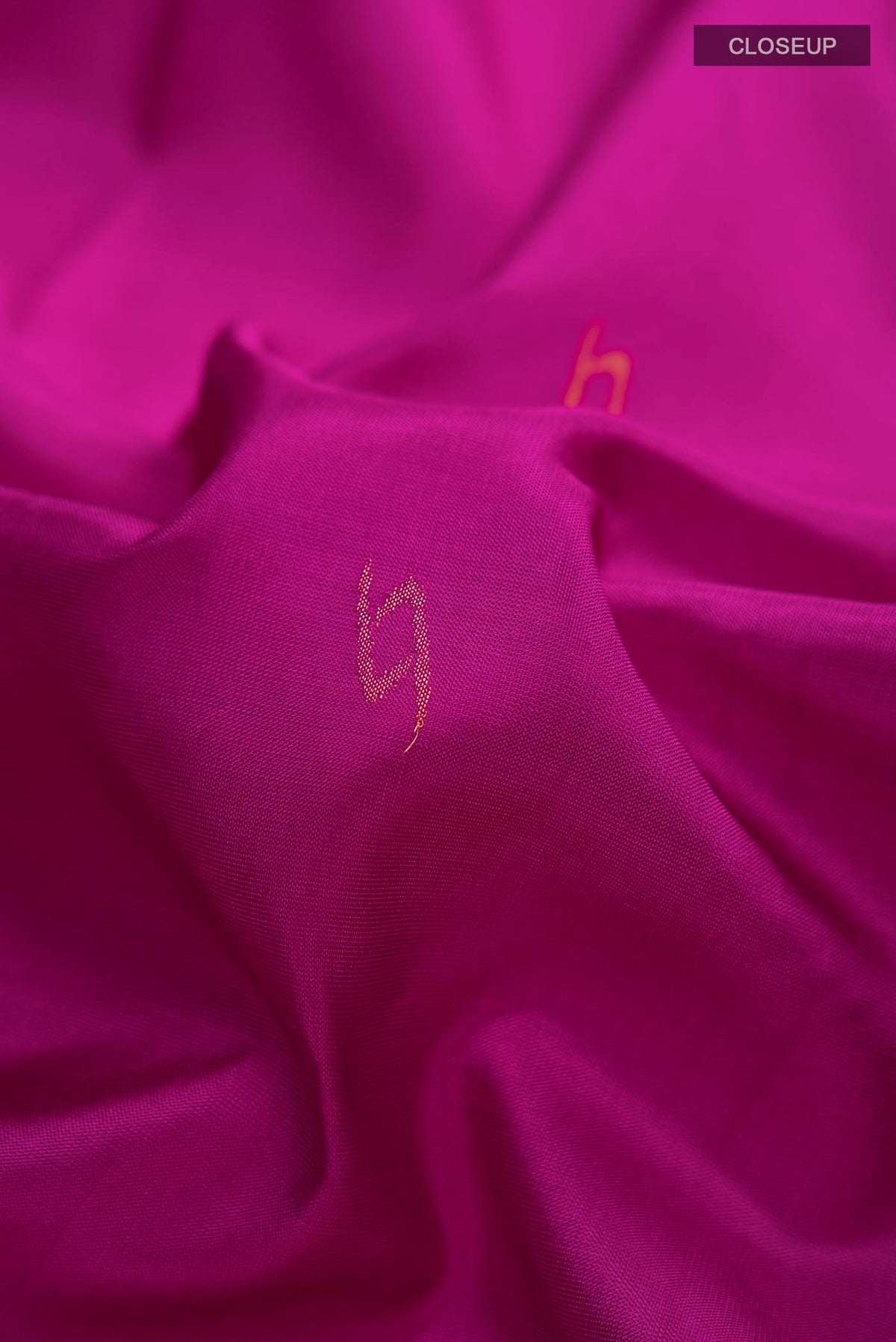 Close up of Magenta Uppada Silk Saree with Thread Butta on the body and Zari Border displaying folds