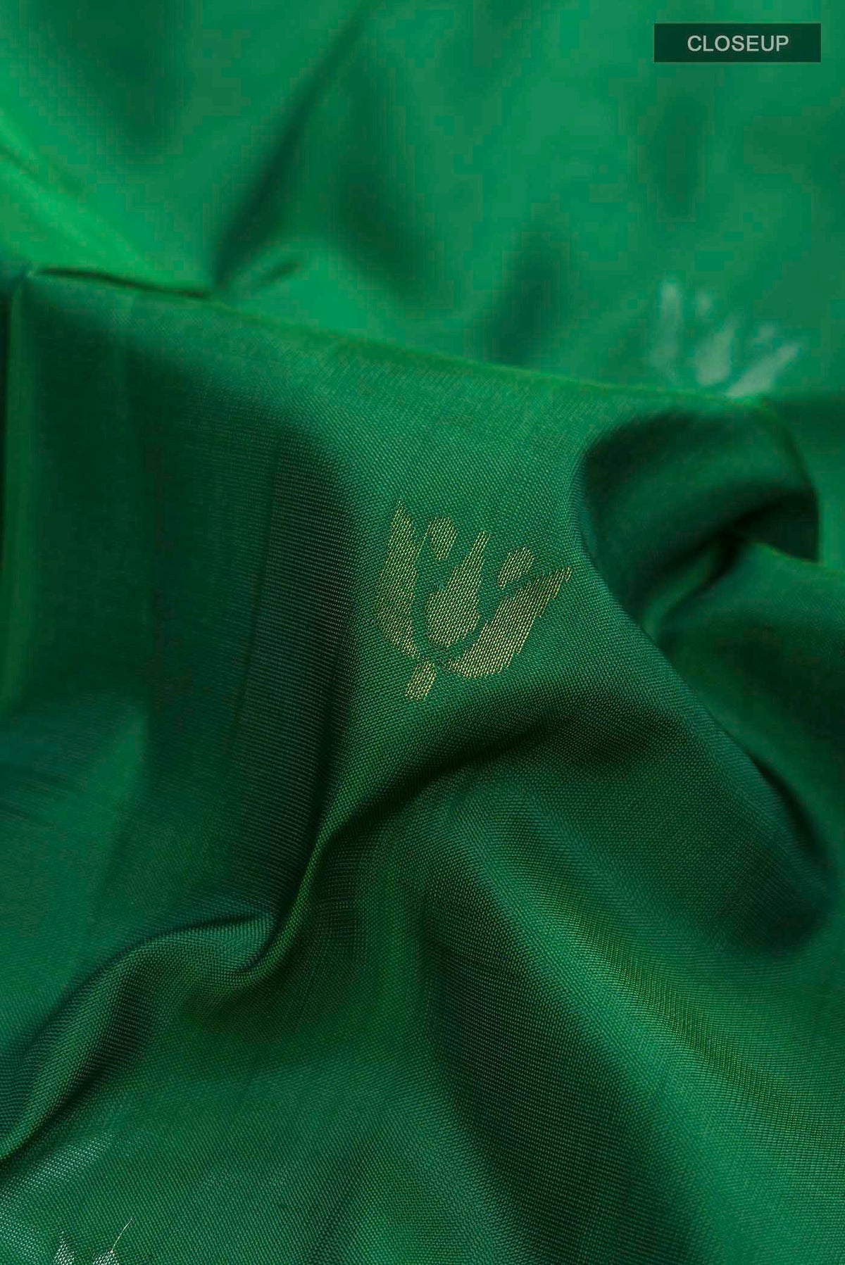 Close up of Green Uppada Silk Saree with Zari Butta on the body and Zari Border displaying folds