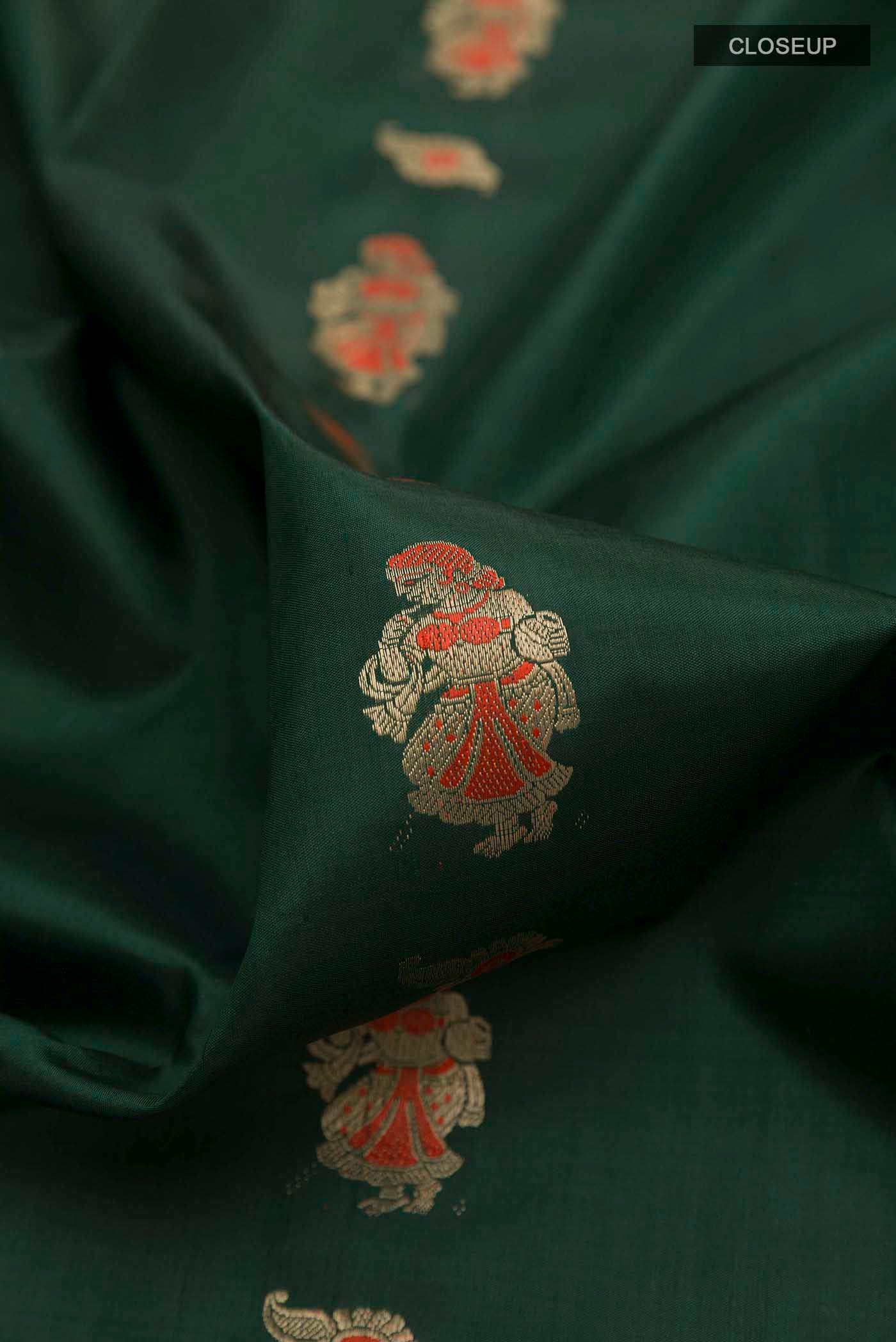 Close up of Green Baluchari Silk Saree with Zari Butta on the body and Zari Border displaying folds