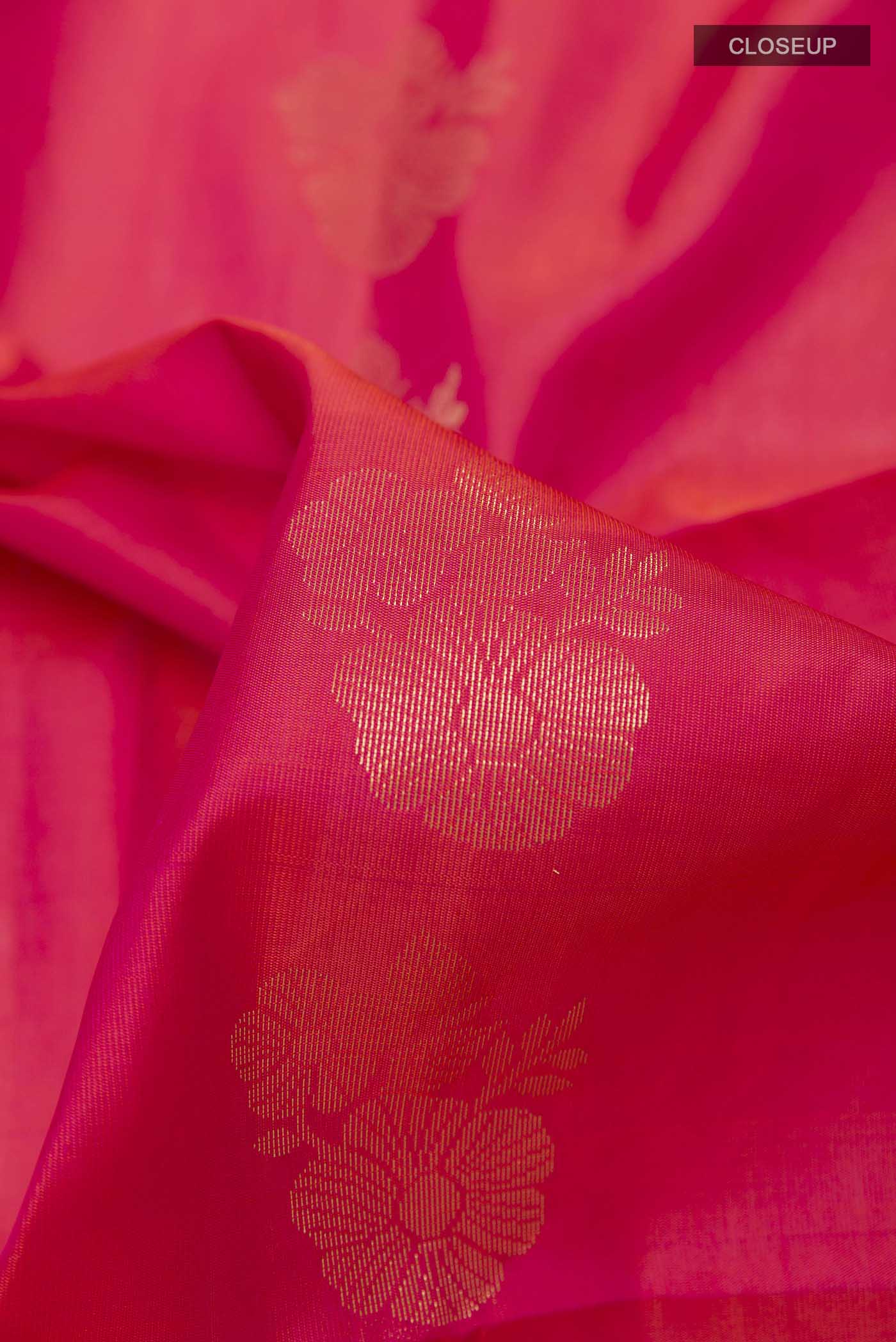 Close up of Pink Dual Tone Soft Silk Saree with Zari Butta on the body and Zari Border displaying folds