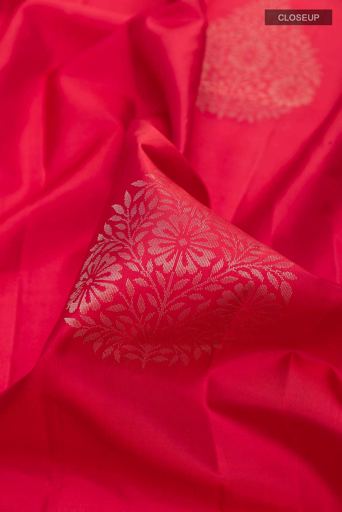 Close up of Red Soft Silk Saree with Zari Butta on the body and Zari Border displaying folds