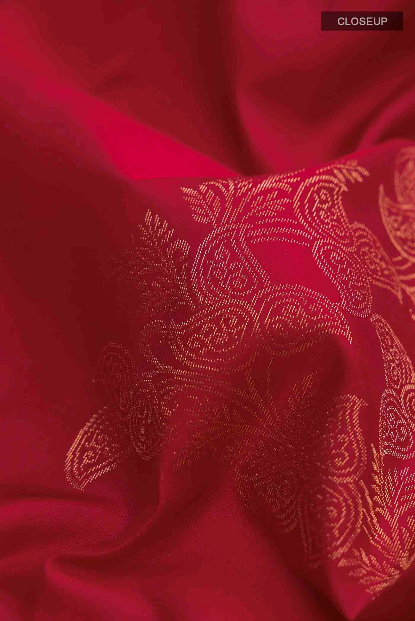 Close up of Maroon Soft Silk Saree with Zari Butta on the body and Zari Border displaying folds
