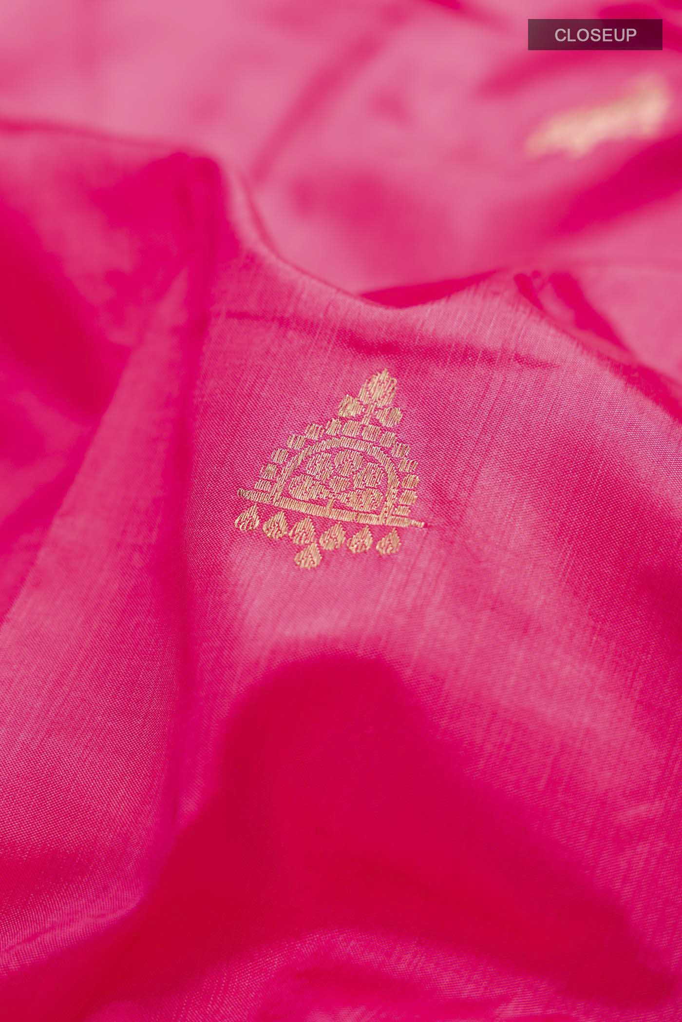 Close up of Coral Banarasi Katan Silk Saree with Zari Butta on the body and Zari Border displaying folds