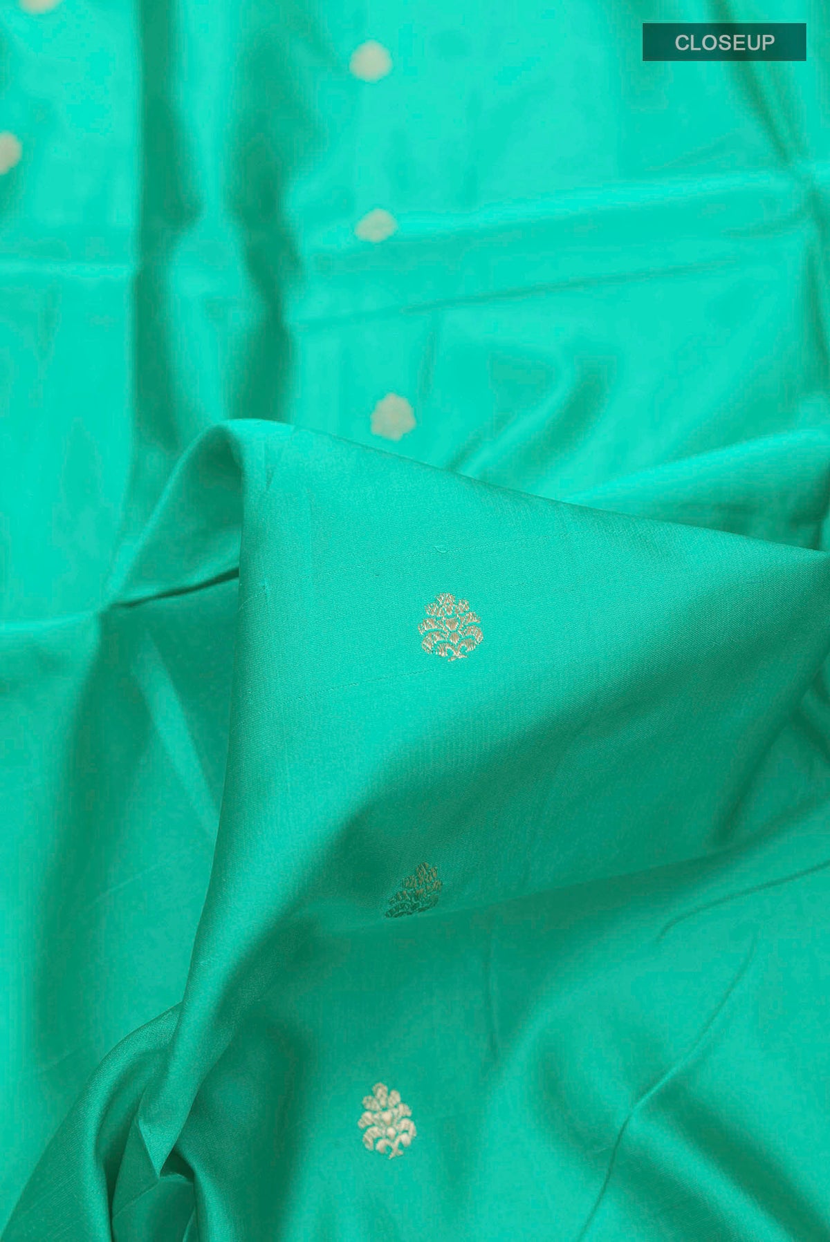 Close up of Sea Green Banarasi Silk Saree with Zari Butta on the body and Zari Border displaying folds