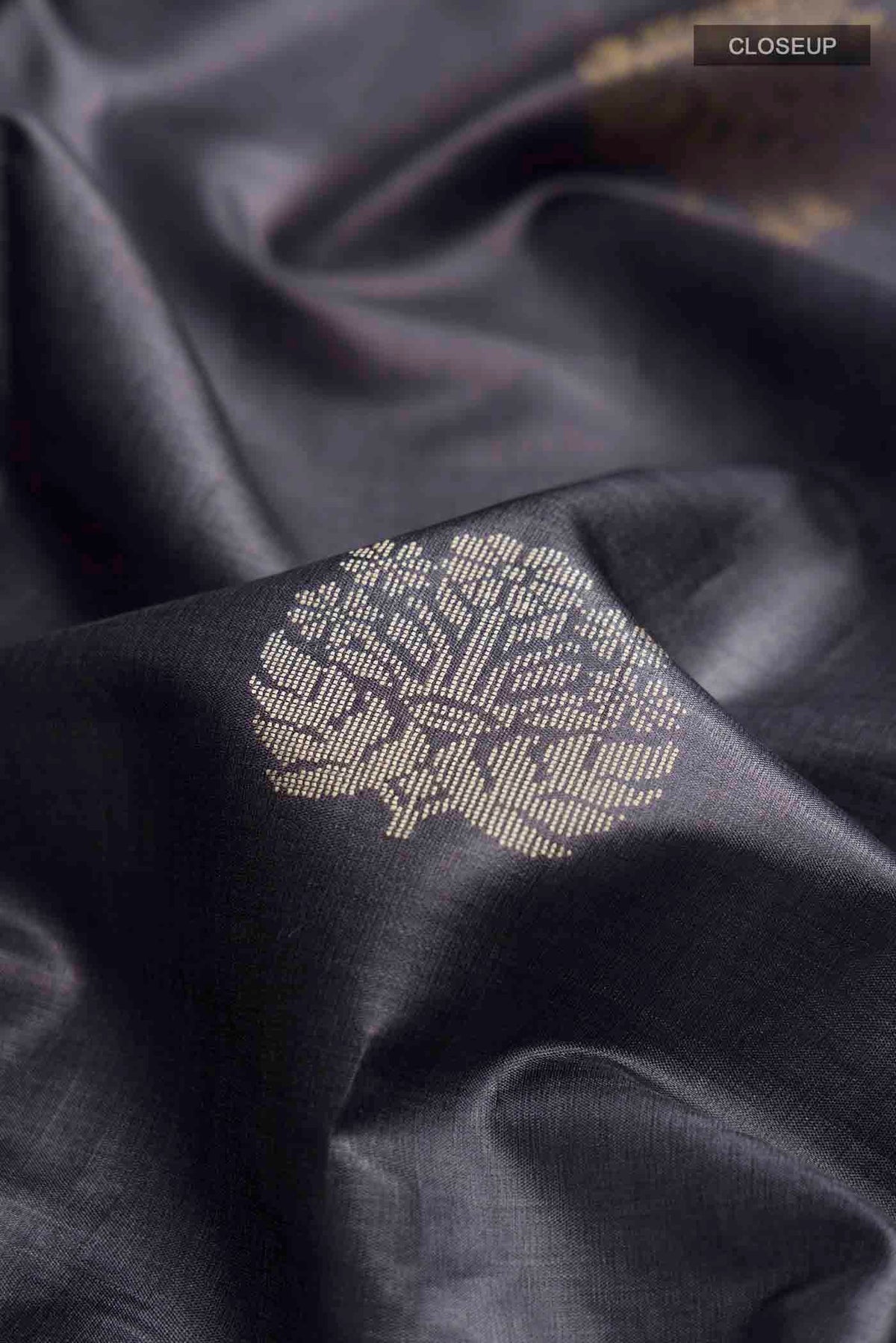 Close up of Grey Tussar Silk Saree with Zari And Thread Butta on the body and Thread Border displaying folds