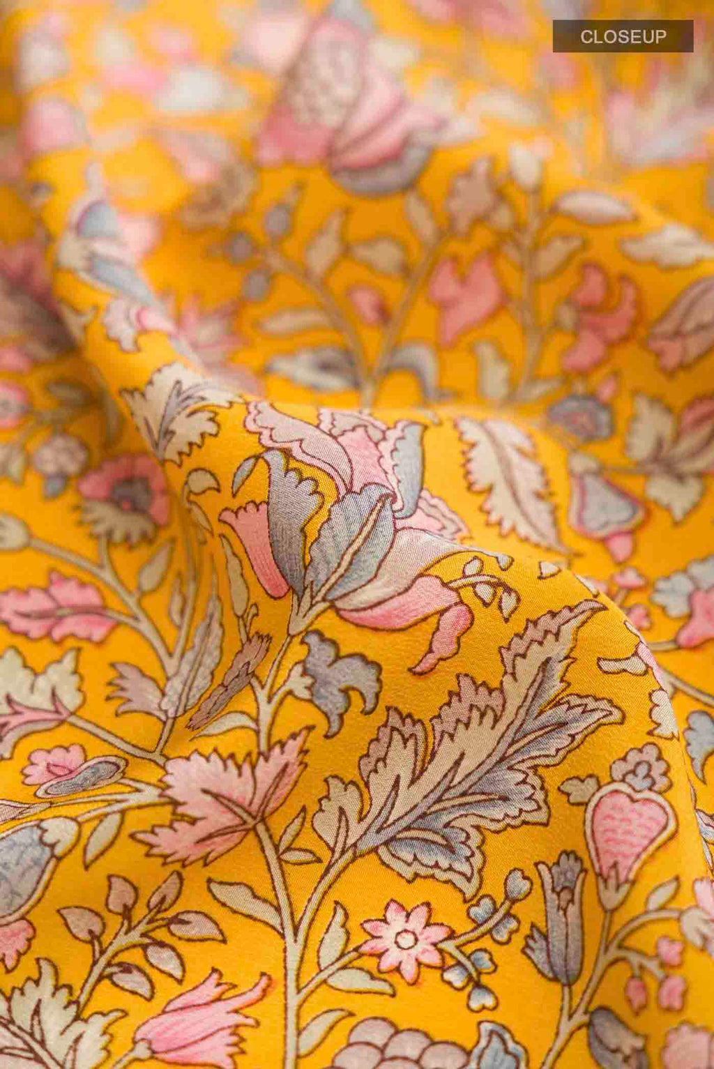 Close up of Yellow Mysore Crepe Saree with Printed design on the body and Printed Border displaying folds