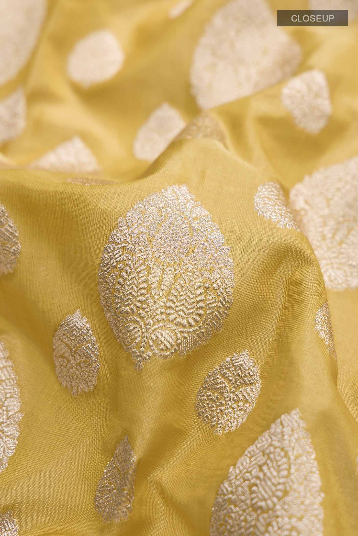 Close up of Yellow Banarasi Silk Saree with Zari Butta on the body and Zari Border displaying folds