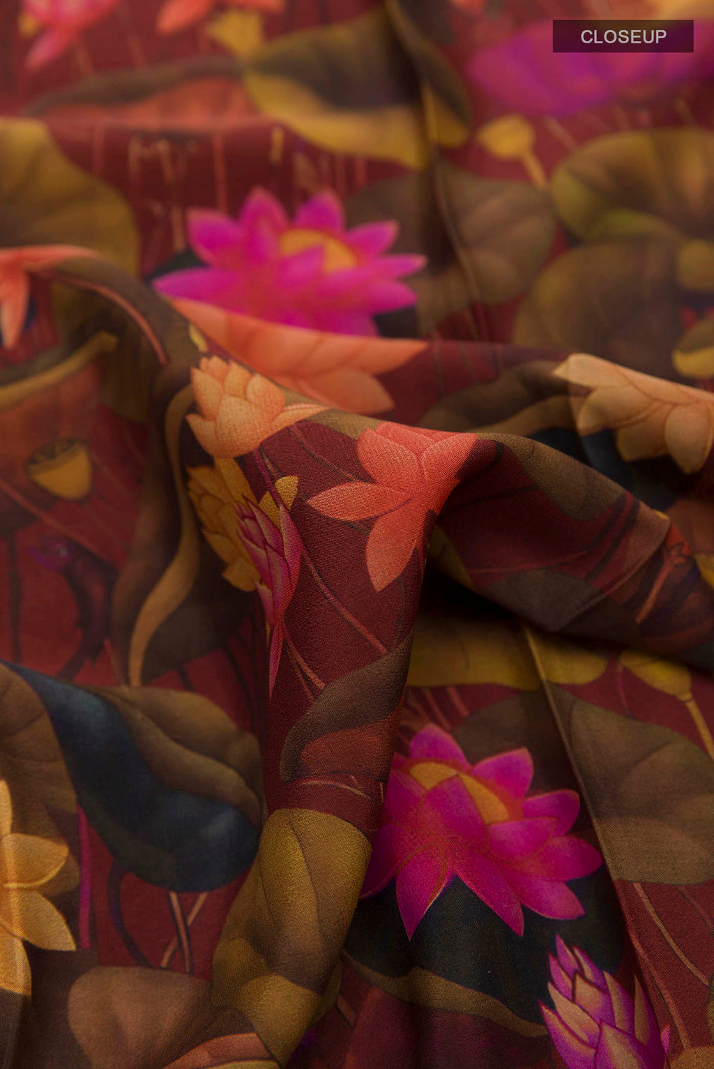 Close up of Maroon Printed Silk Saree with Printed design on the body and Zari Border displaying folds