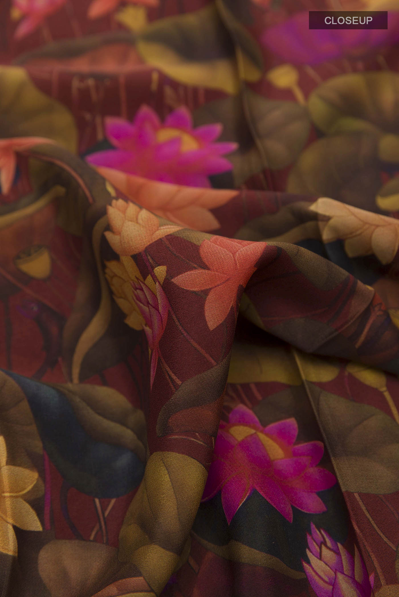 Close up of Maroon Printed Silk Saree with Printed design on the body and Zari Border displaying folds