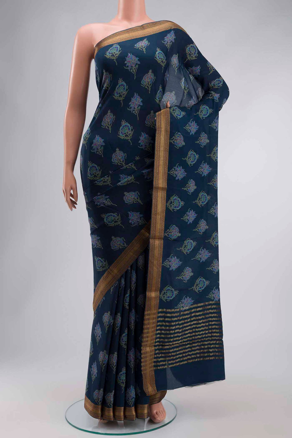 Blue Crepe Saree with Printed design on the body and Zari Border displayed on a mannequin