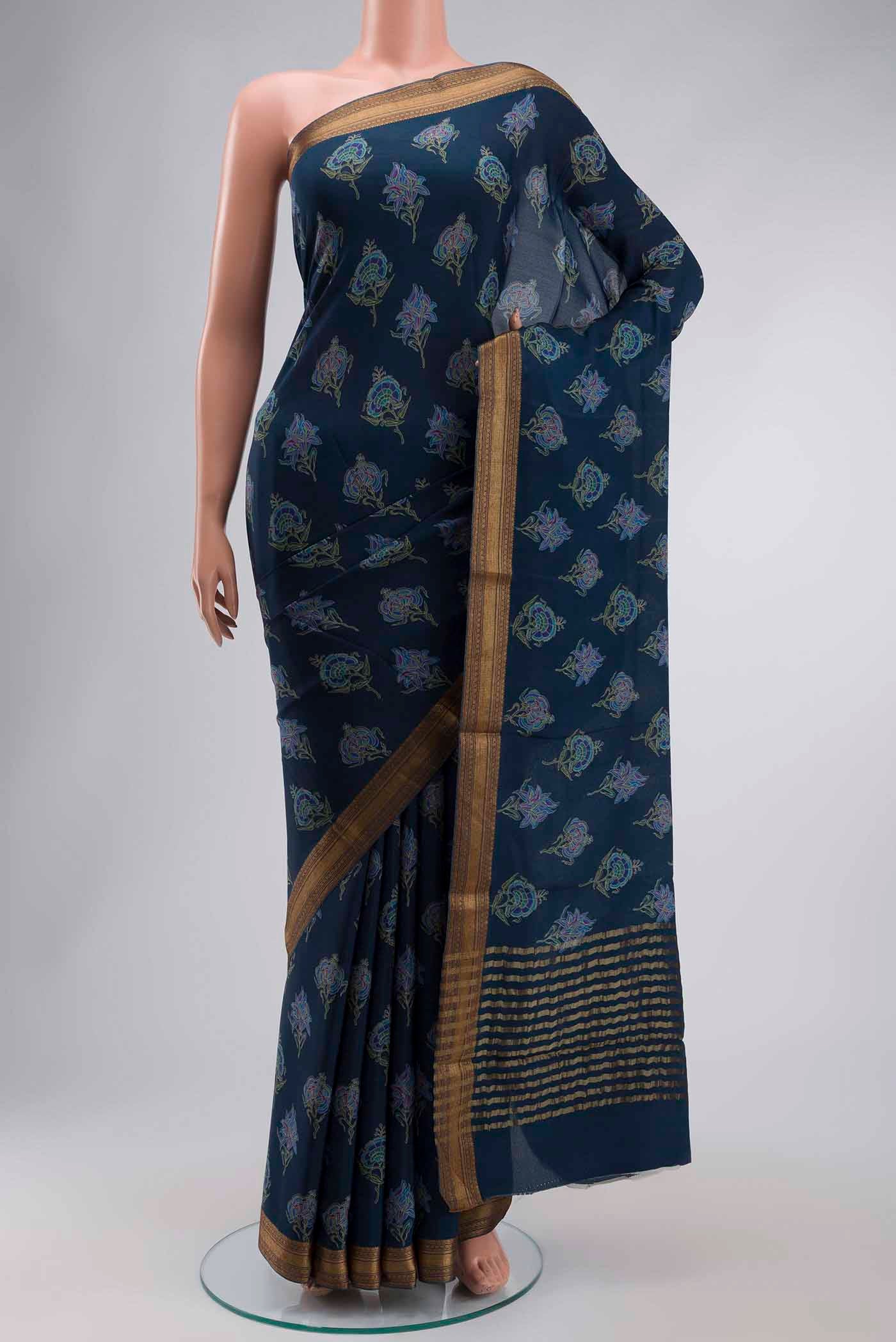 Blue Crepe Saree with Printed design on the body and Zari Border displayed on a mannequin
