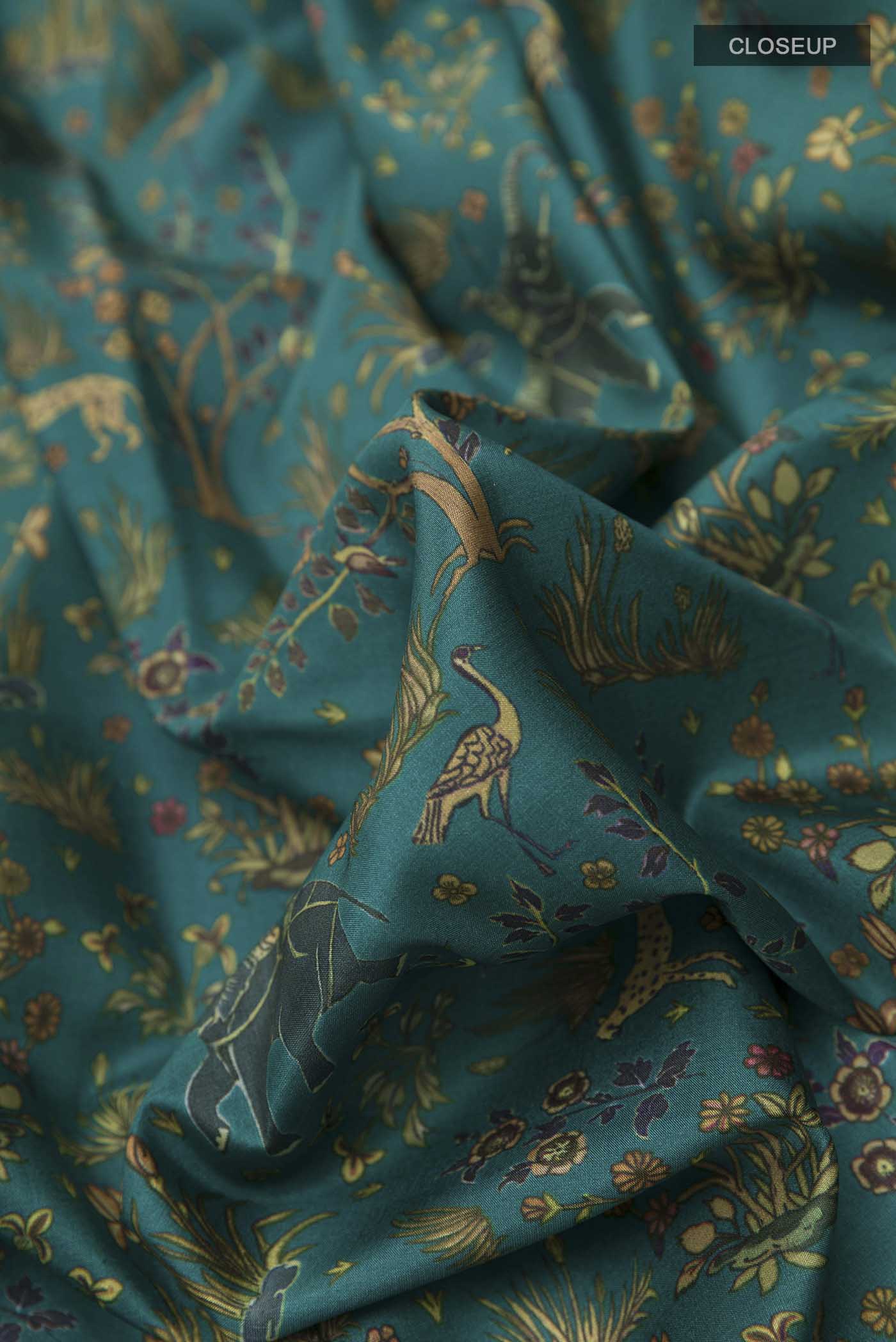 Close up of Green Printed Silk Saree with Printed design on the body and Zari Border displaying folds