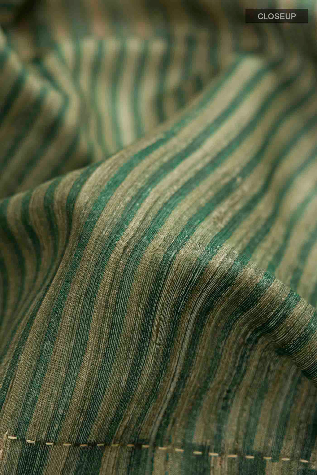 Close up of Green Tussar Silk Saree with Stripes on the body and Zari Border displaying folds